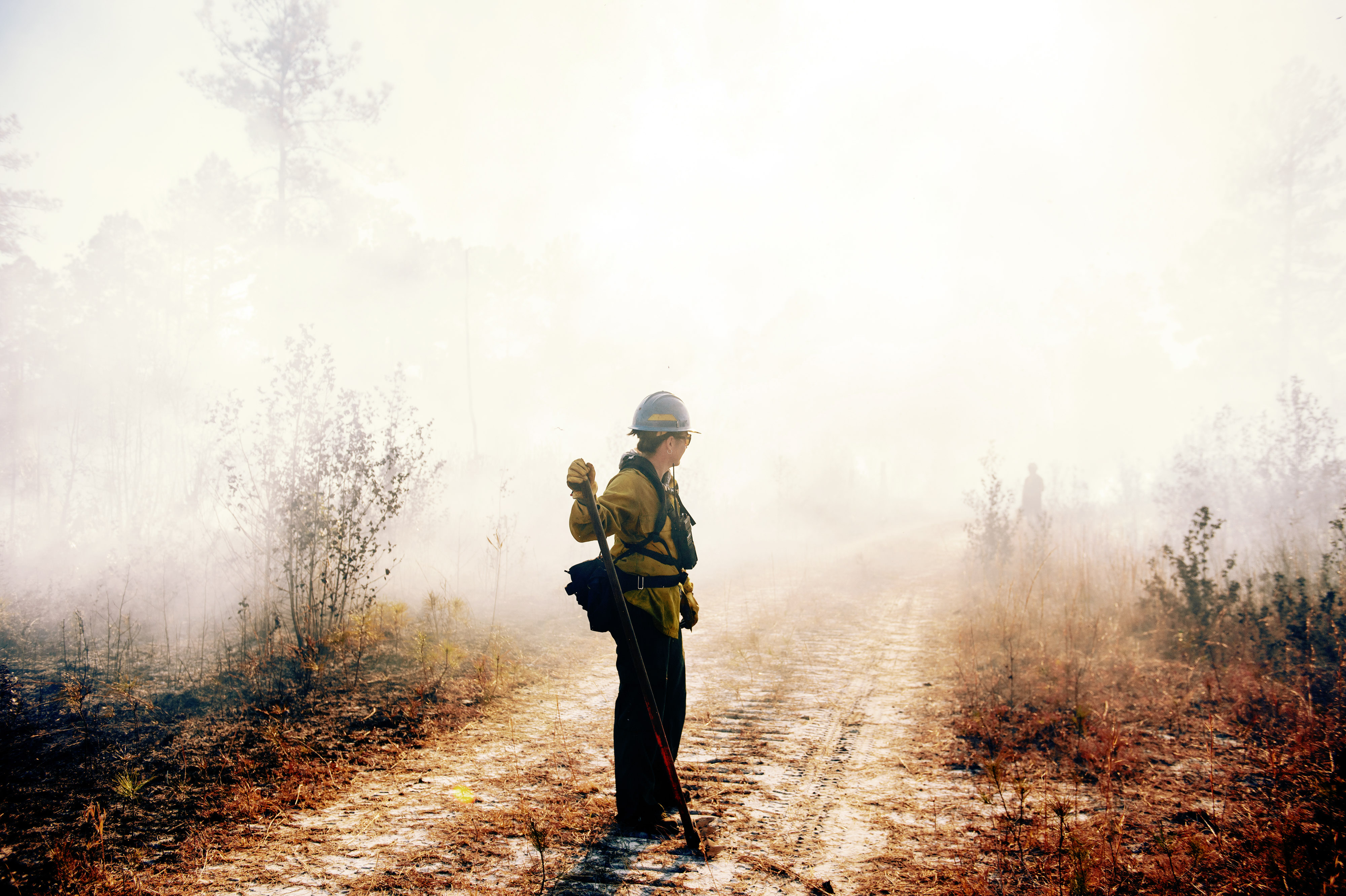 Woman standing in smoke of controlled burn.