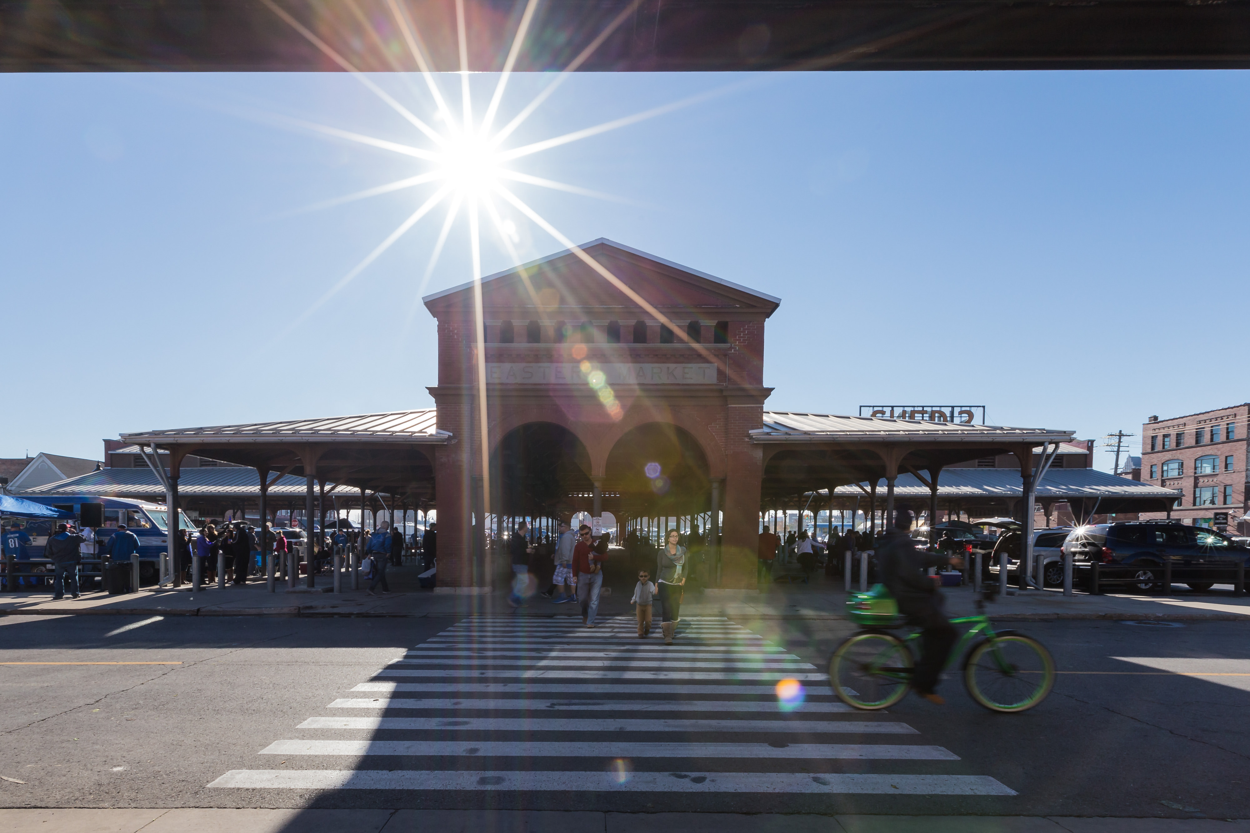 The sun shines over a crowded open-air market.