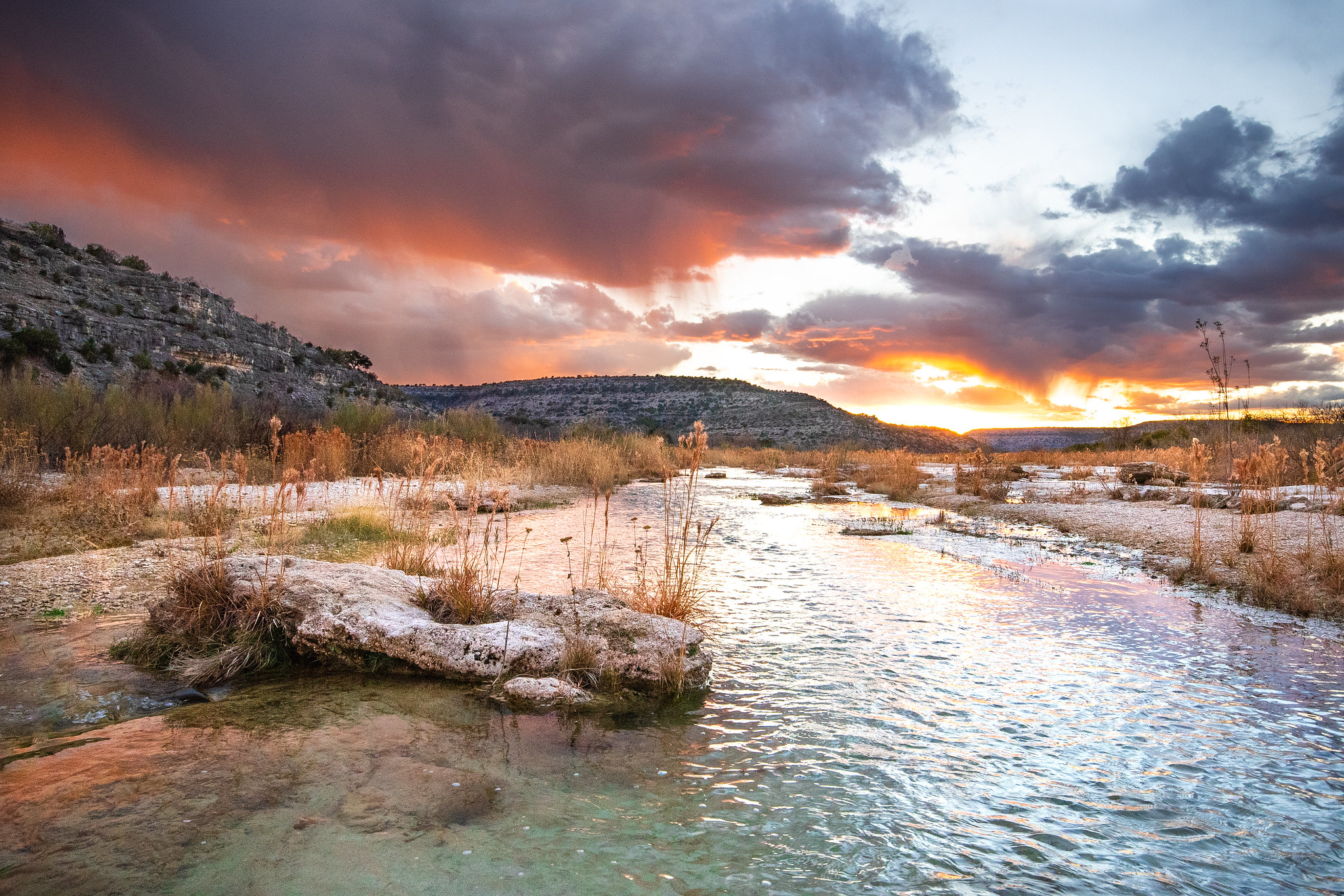 A rocky creek runs through a dry landscape.