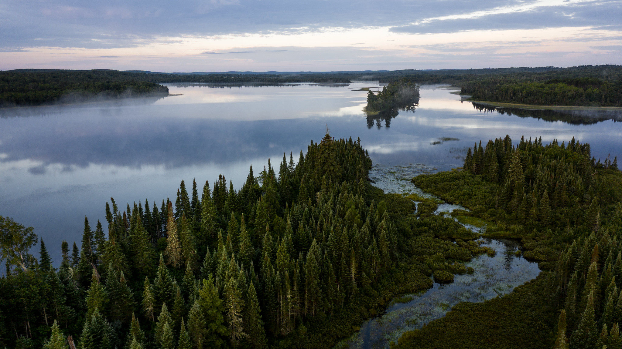 Aerial view of an undeveloped freshwater lake surrounded by forest.