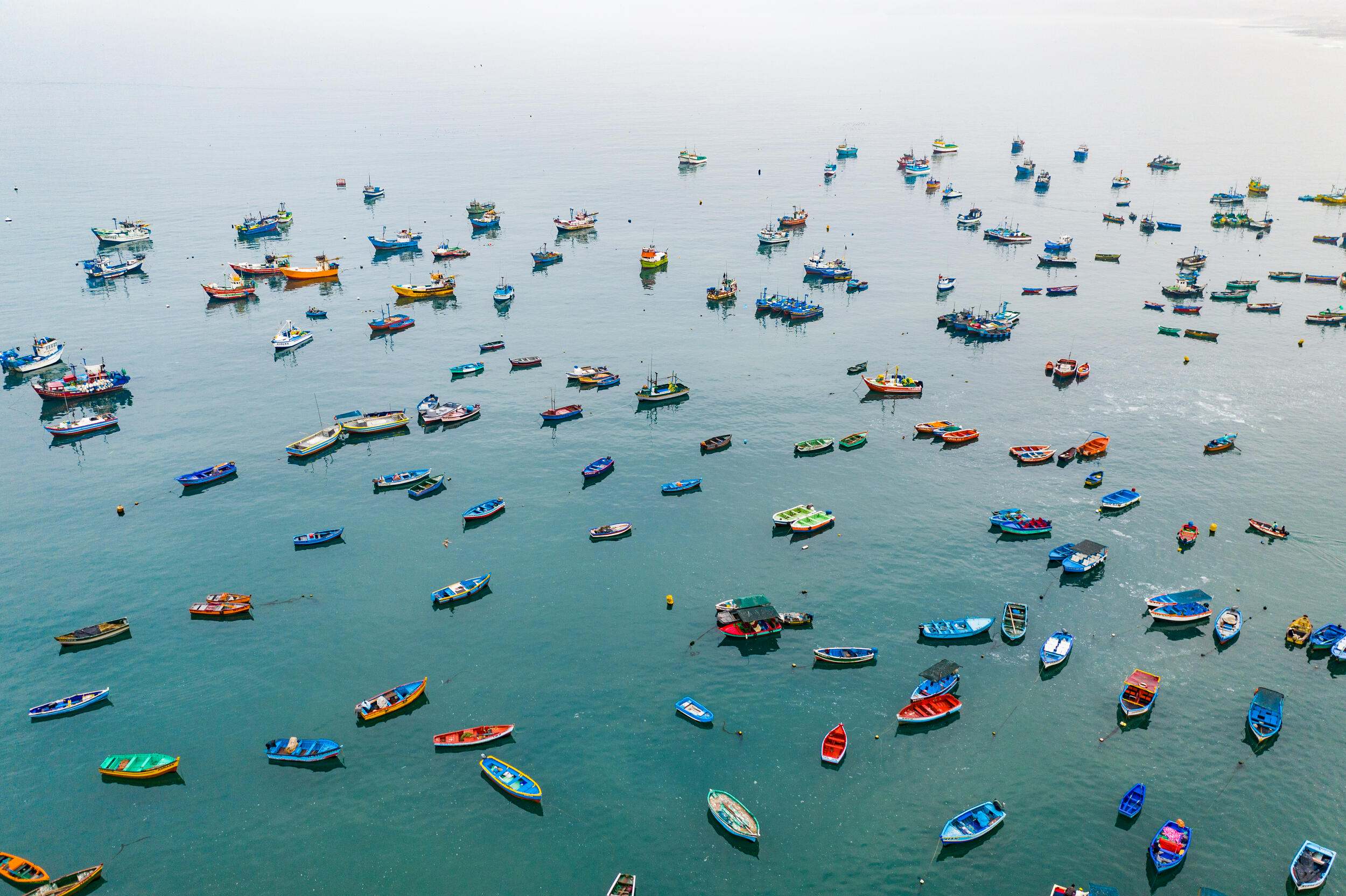 Colorful fishing boats fill a harbor in Ancón, Peru.