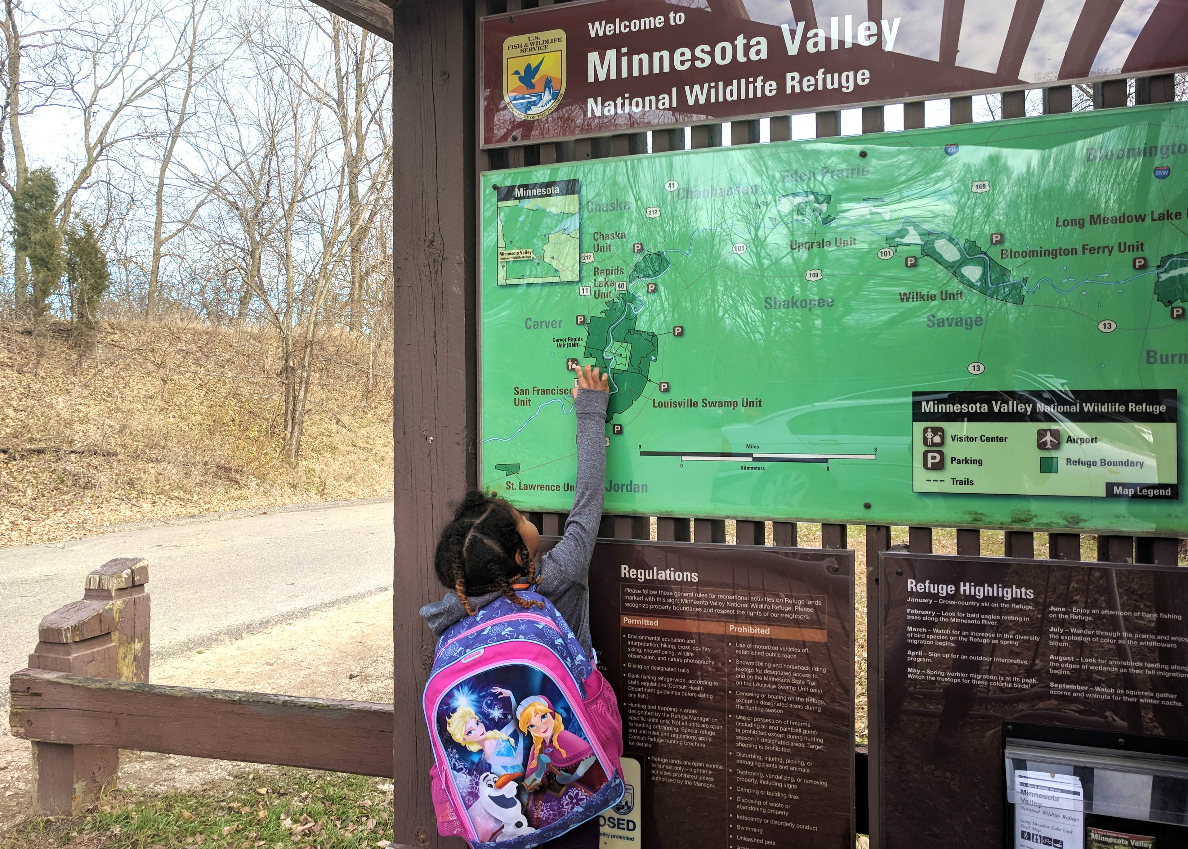 A small child points to a map at the Minnesota Valley National Wildlife Refuge.