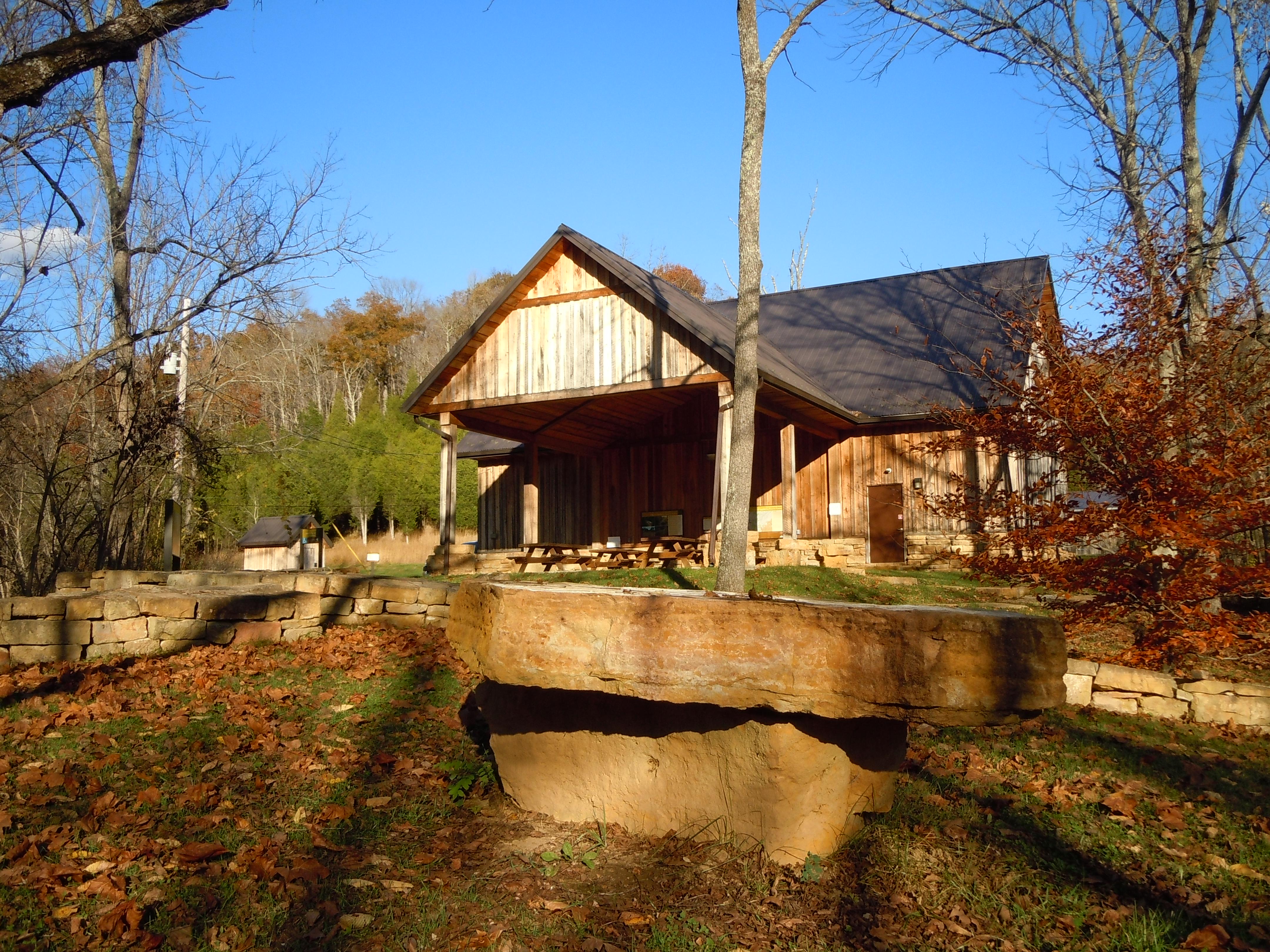 A visitor pavilion building nestled among trees under a blue sky in autumn.