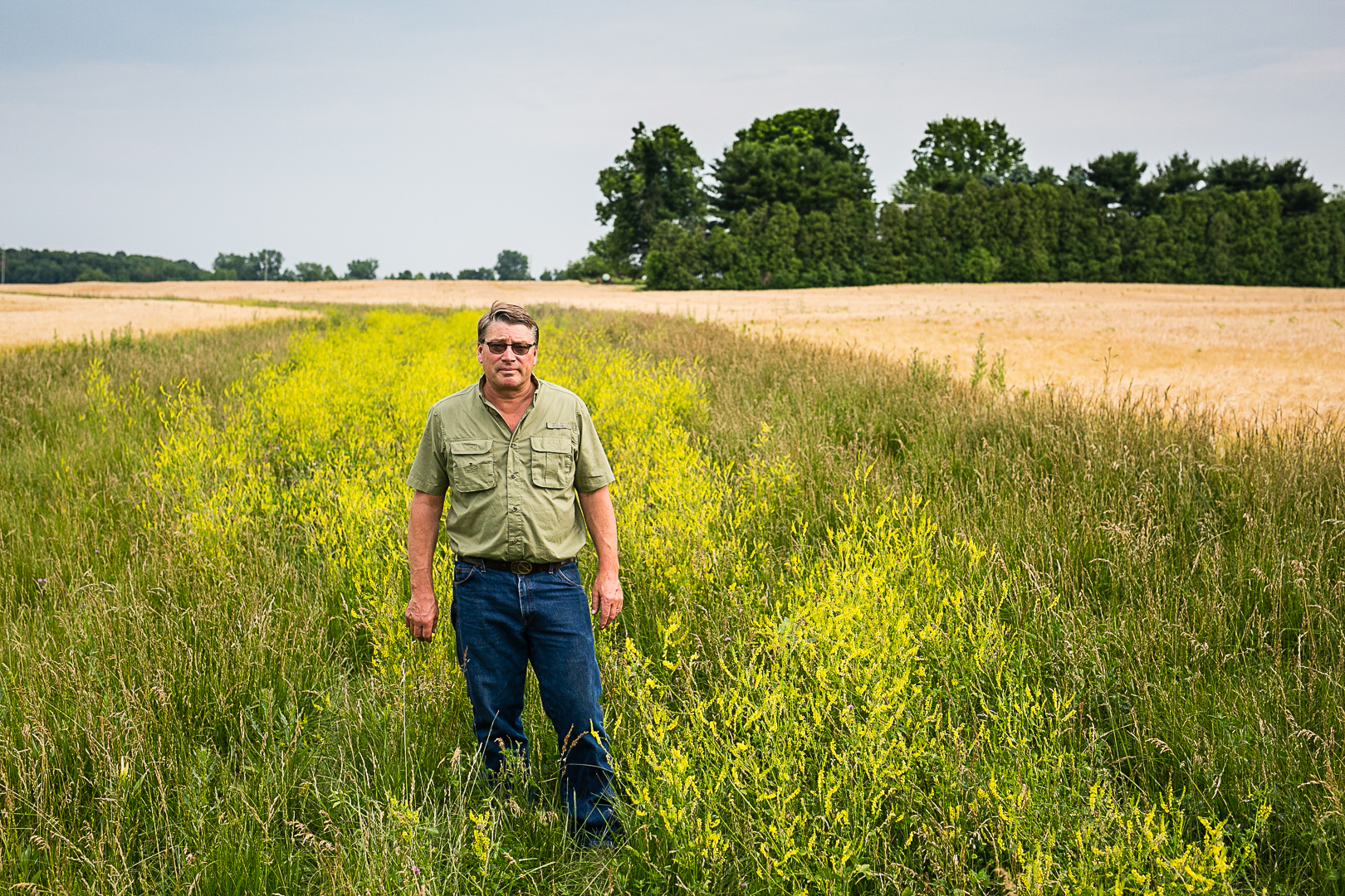 Farmer Les Seiler stands next to two-stage ditch in his agricultural field.