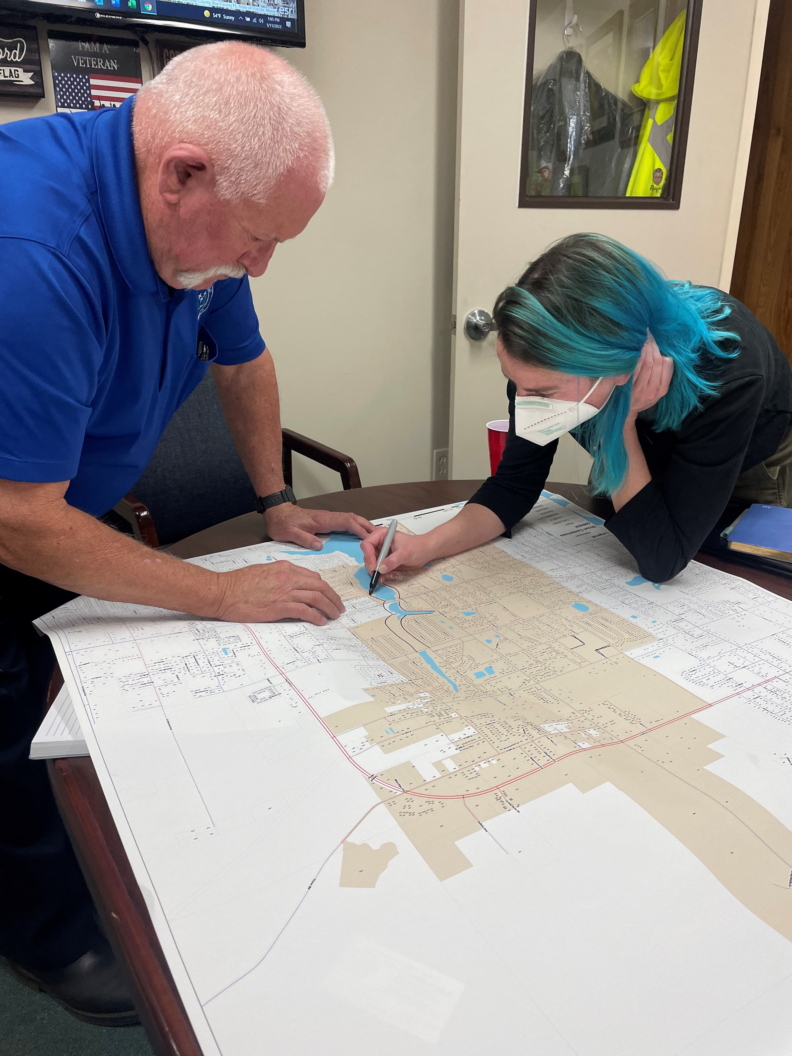 Two people work at a table over a map to determine locations for nature based solutions.