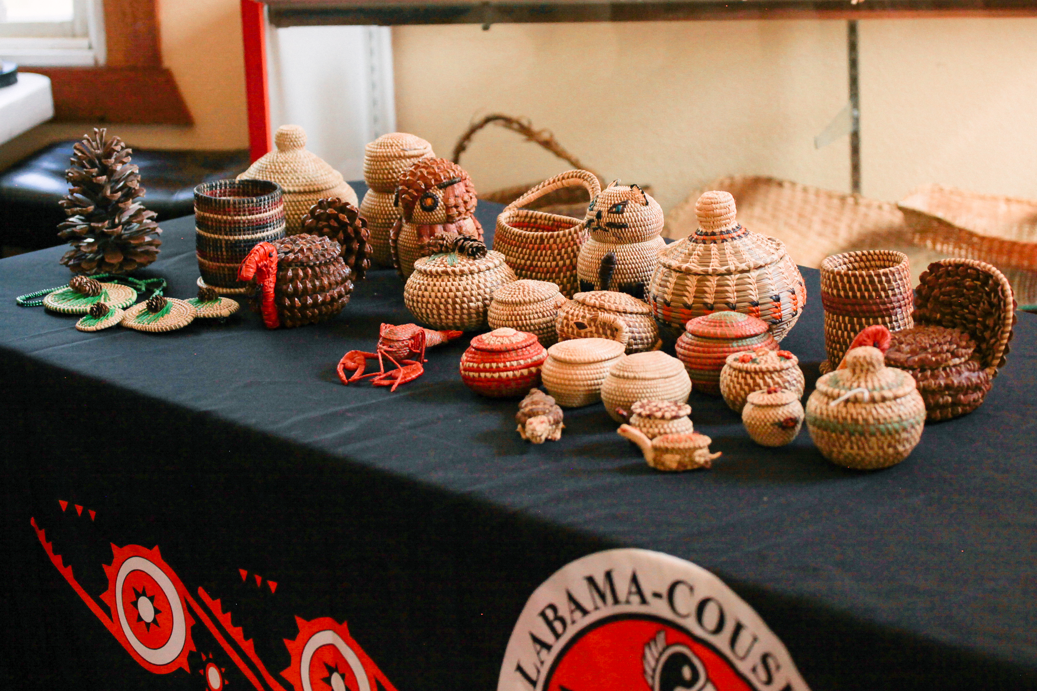  A table filled with woven baskets and animals.