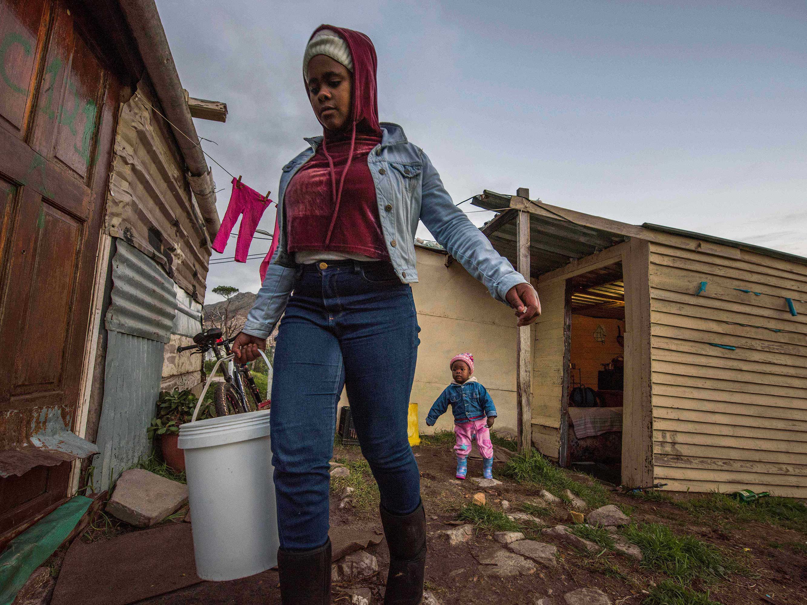 woman carries bucket of water in cape town south africa