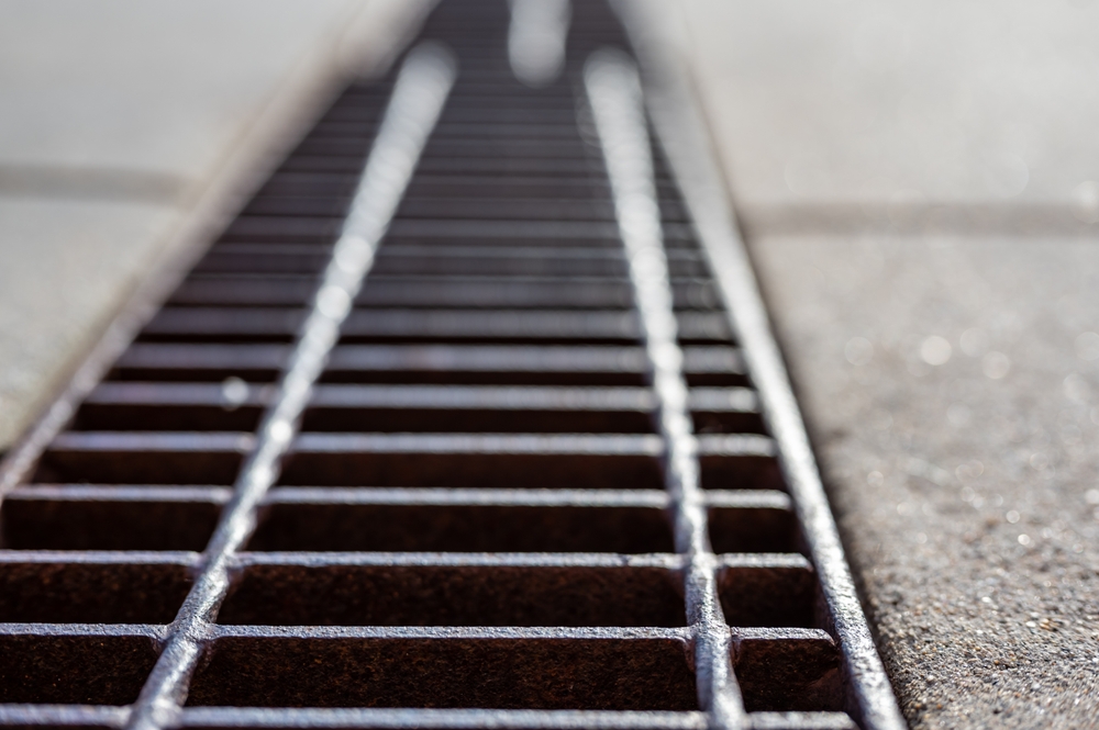 Close-up of the metal grate over a catch basin.