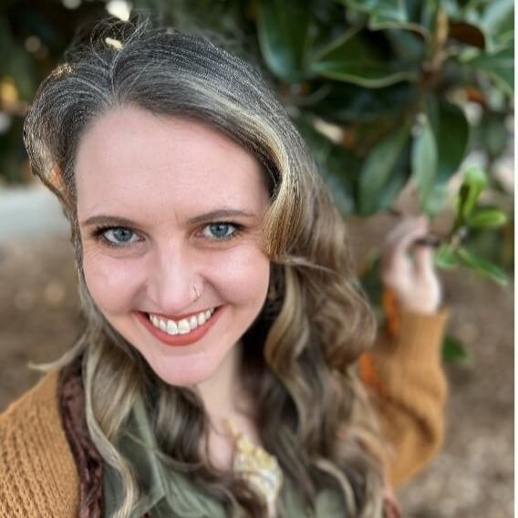 Selfie of poet, Chelsea Krieg, smiling from an overhead angle.