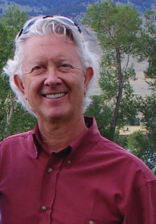 A man with sunglasses on his head smiles.