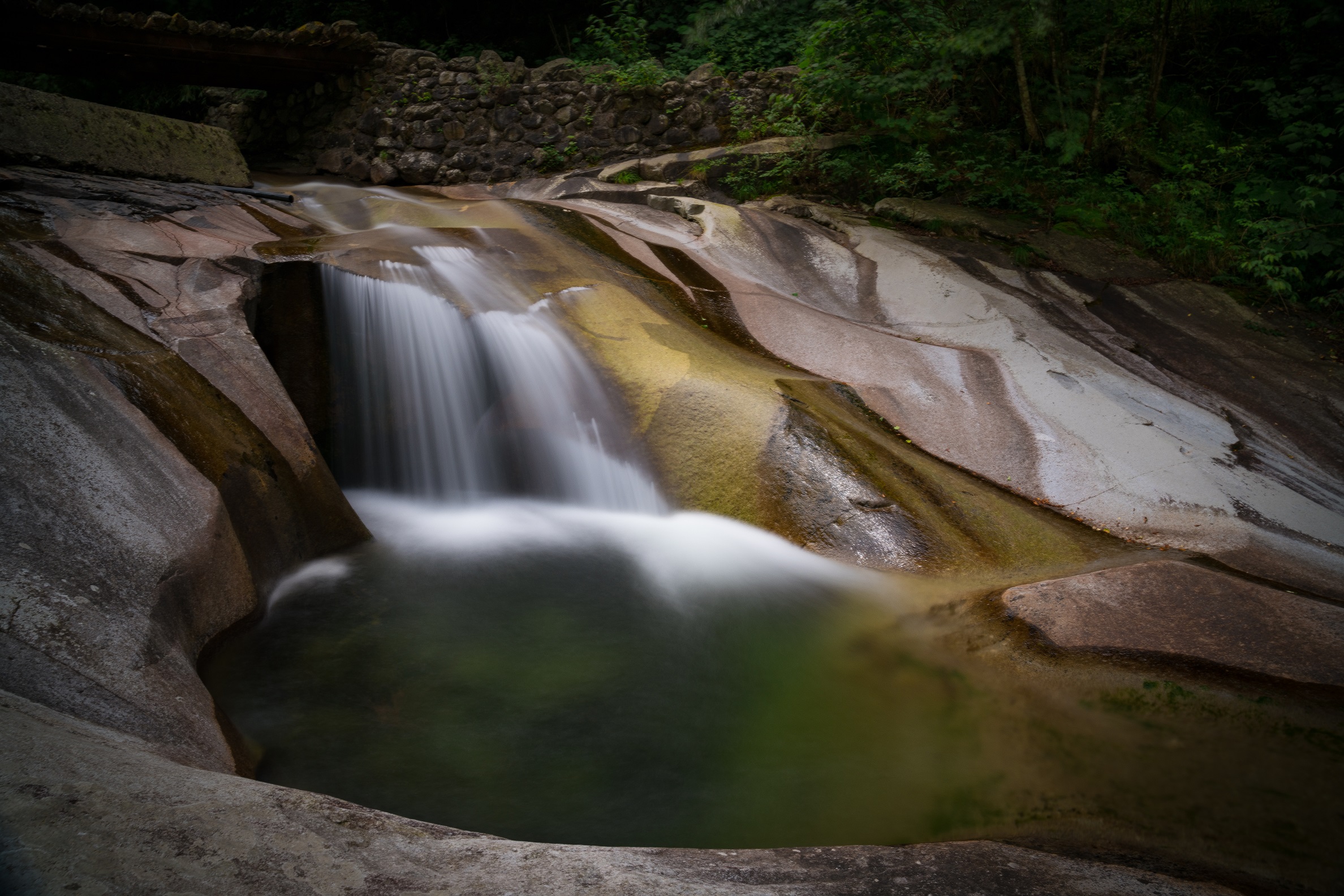 A running stream flows over rocks in Laohegou, Sichuan Province.