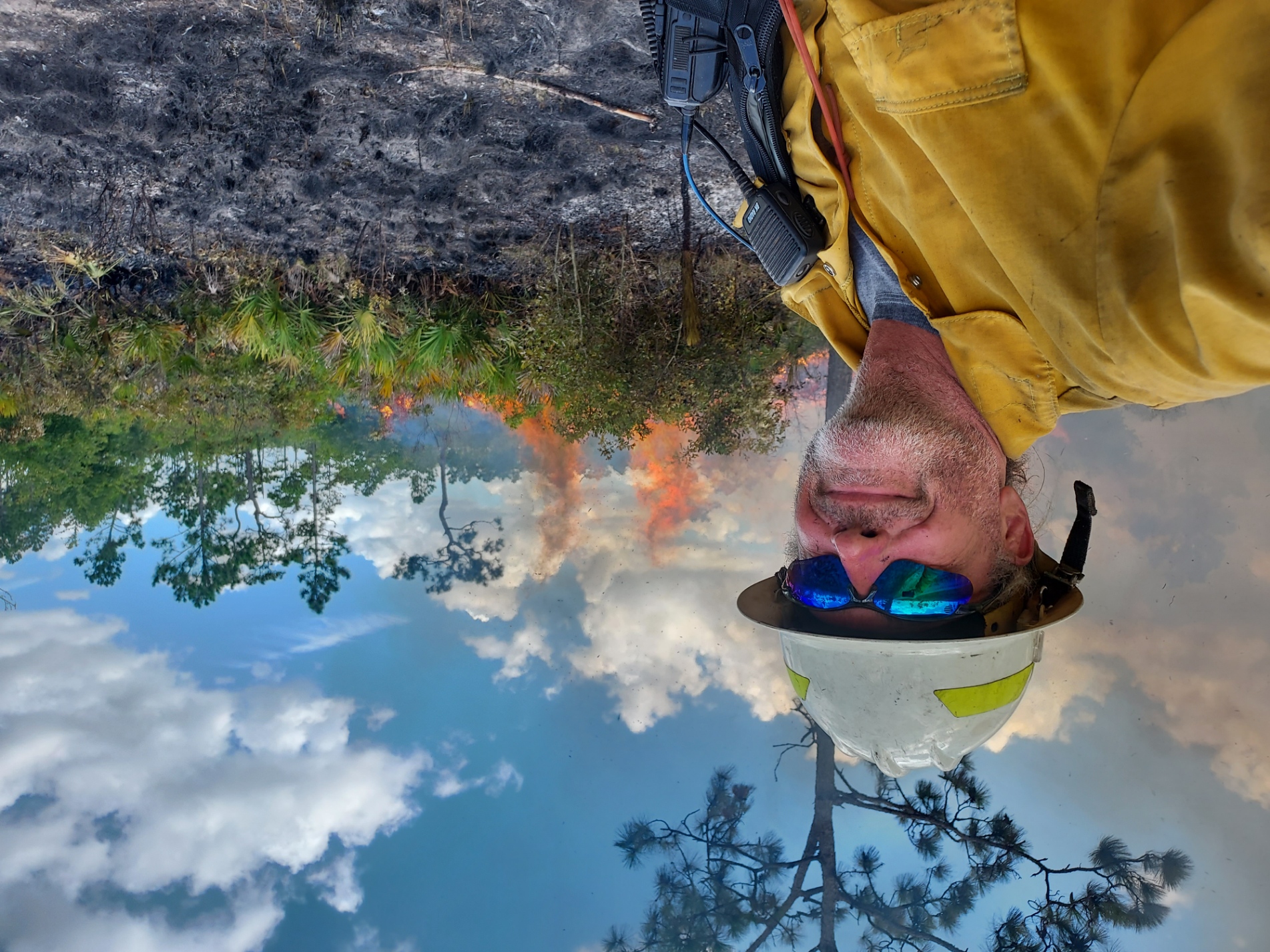 Florida fire program director David Printiss stands against a controlled burn in a forest at Apalachicola Bluffs and Ravines Preserve. 
