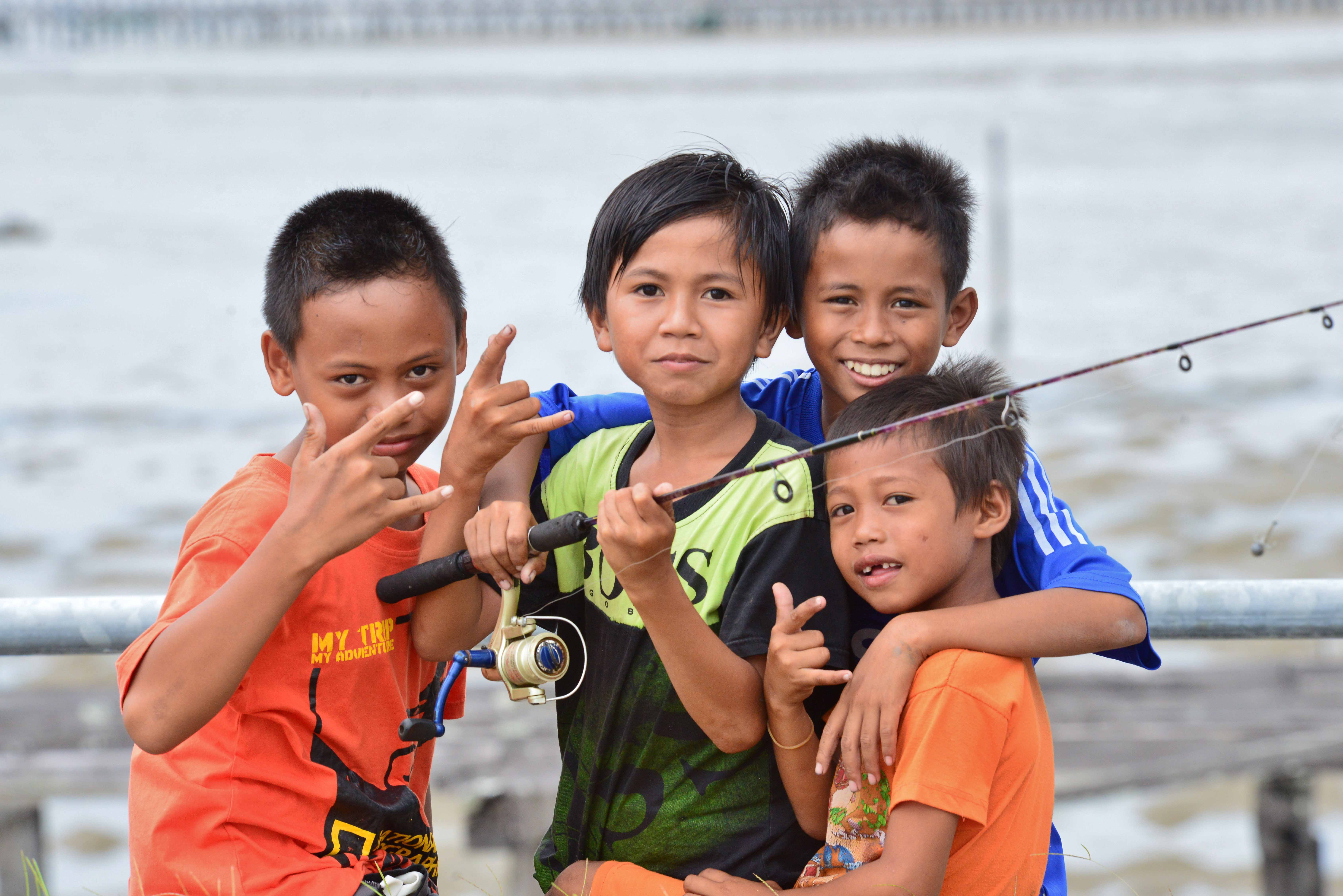 Children fishing on a pier in Indonesia