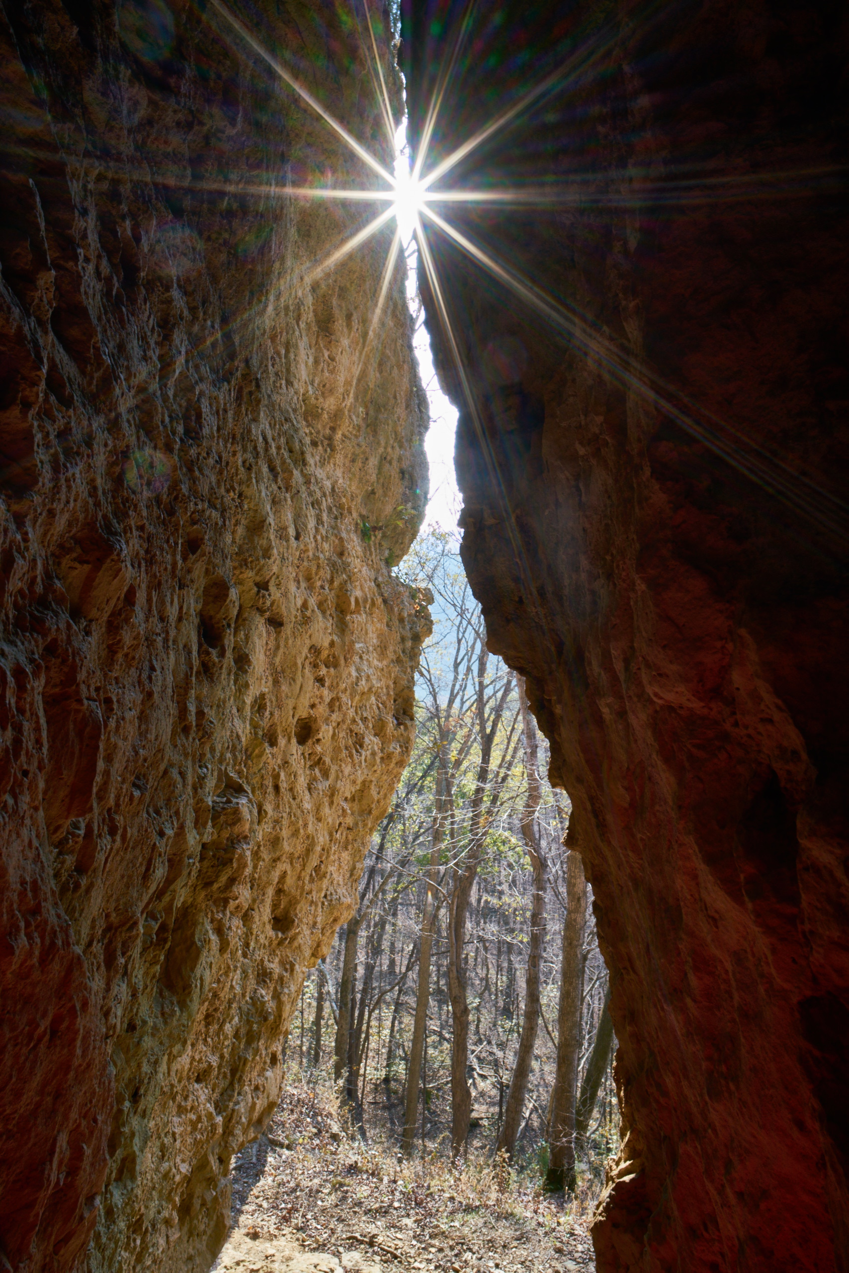 Sunlight shines through a crevice between two rock walls.