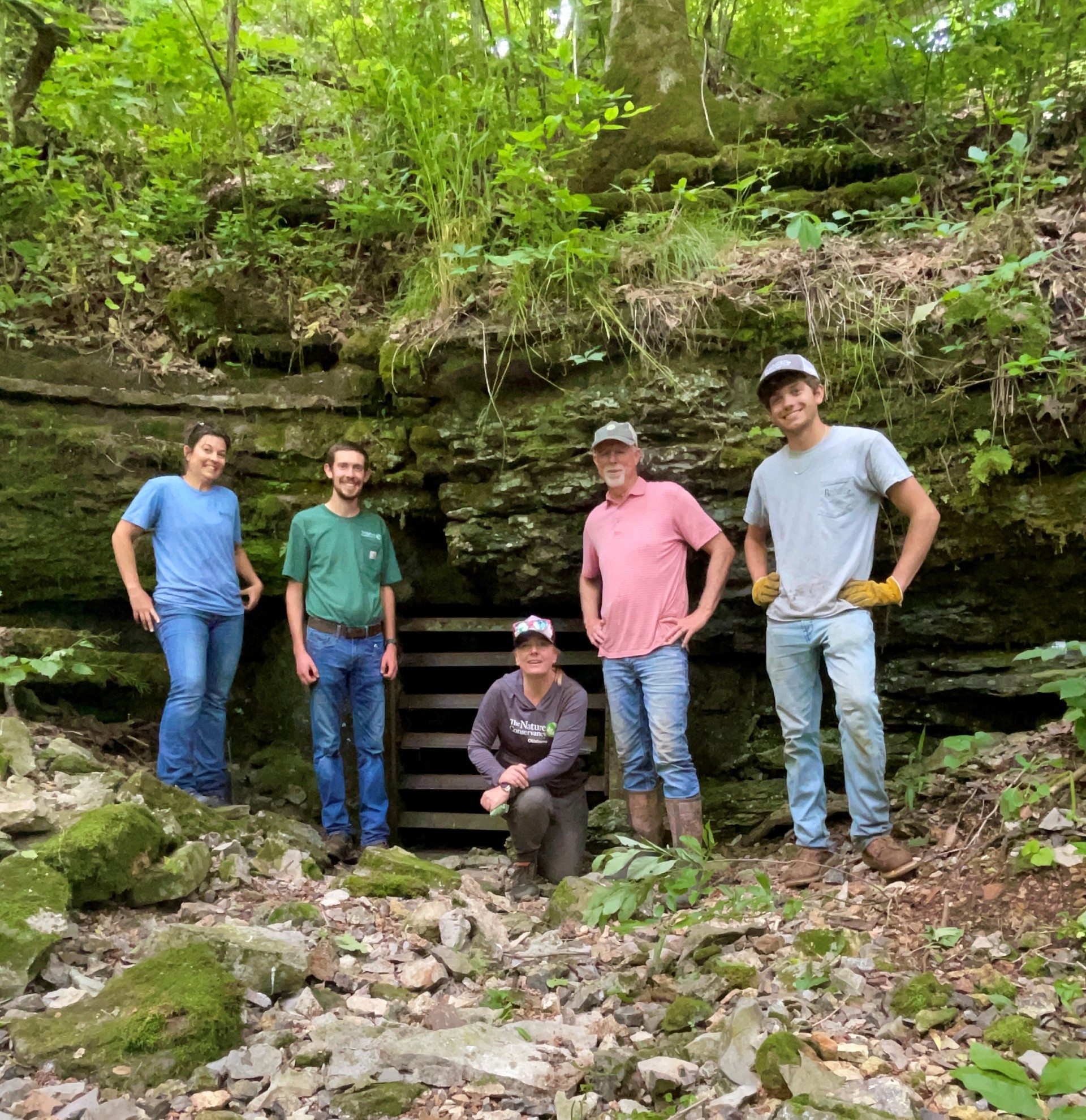 The Eucha Gate Team standing in front of a gated opening that protects an entrance into the subterranean ecosystems below.  