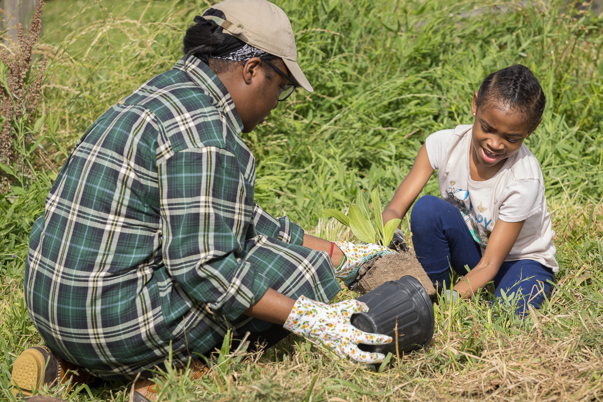 Two young volunteers plant native seedlings in Houston, Texas.