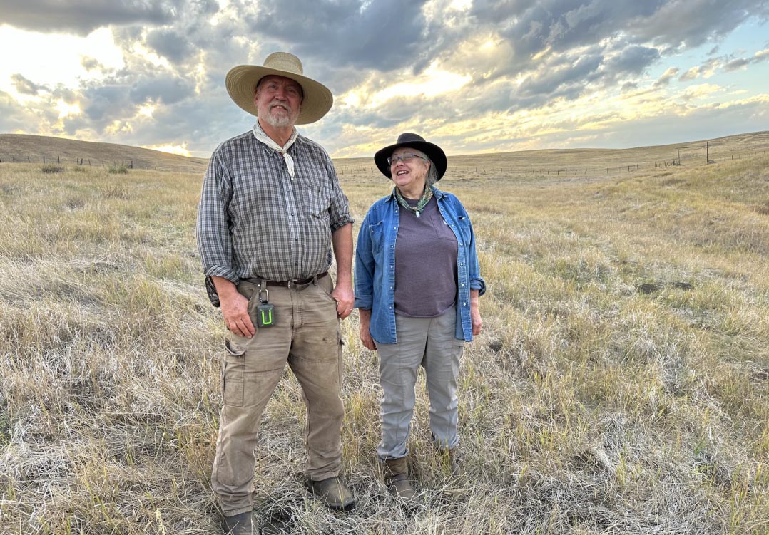 Two volunteers standing out in a field.