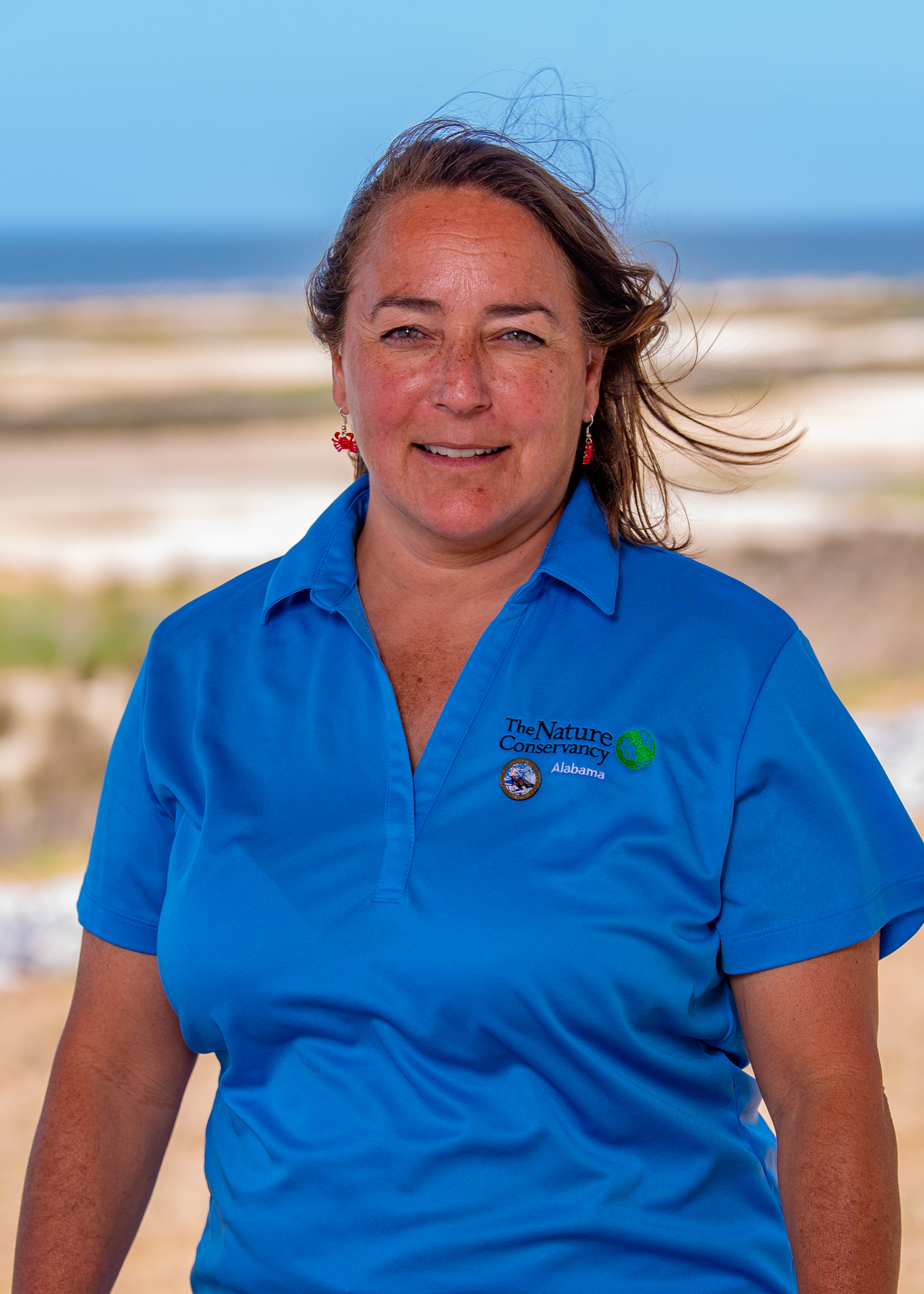  Headshot of Judy Haner in front of a sandy shore.