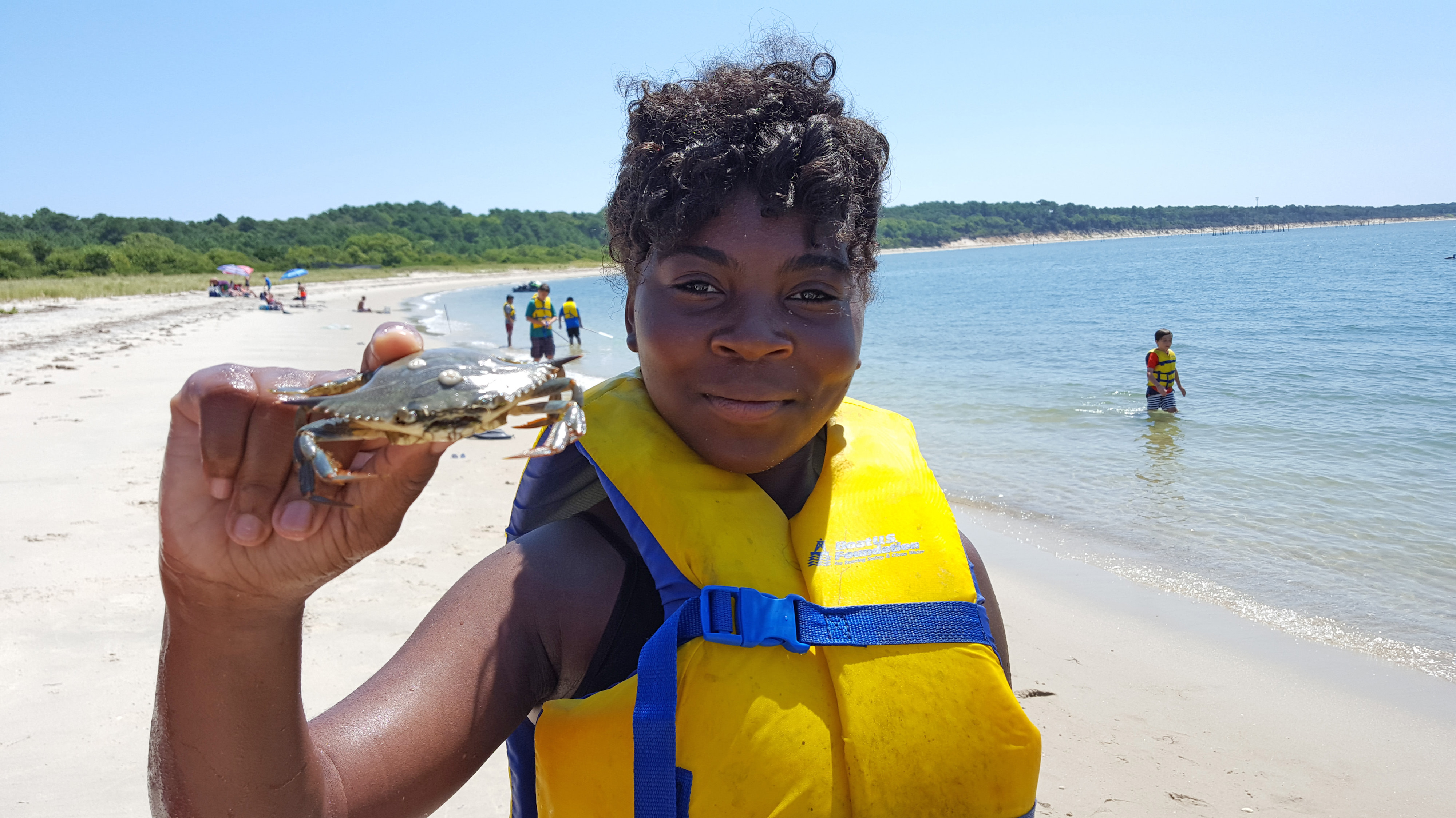 A girl holds up a crab at the Virginia Coast Reserve