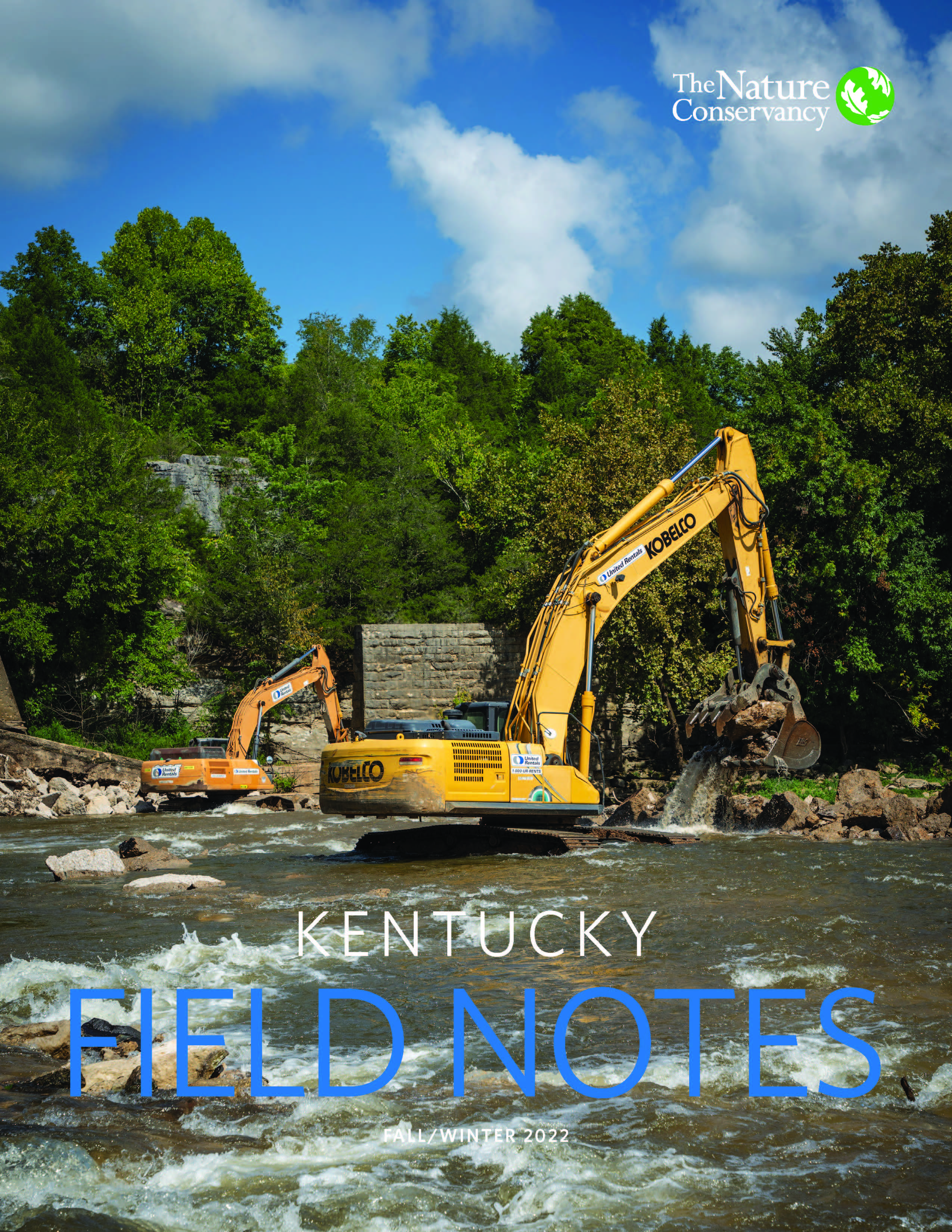 A bulldozer works at a dam removal site in a river.