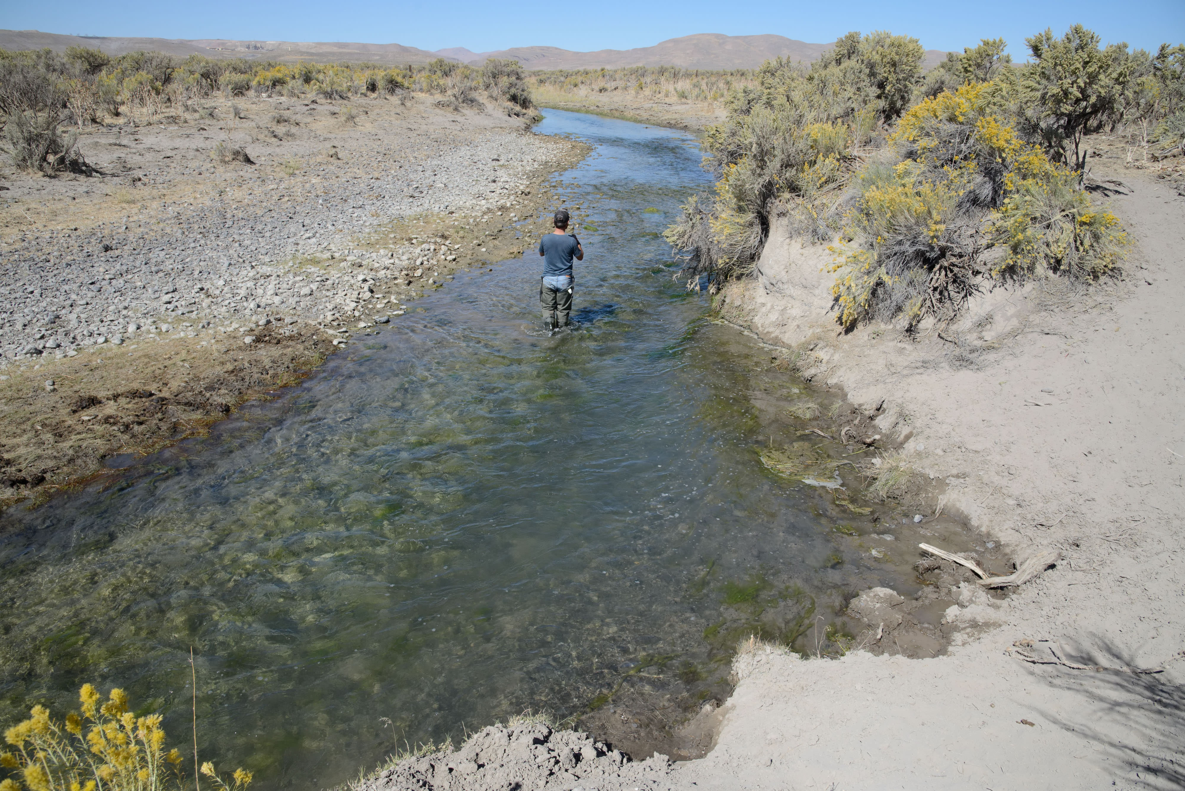 A person standing in a stream. 