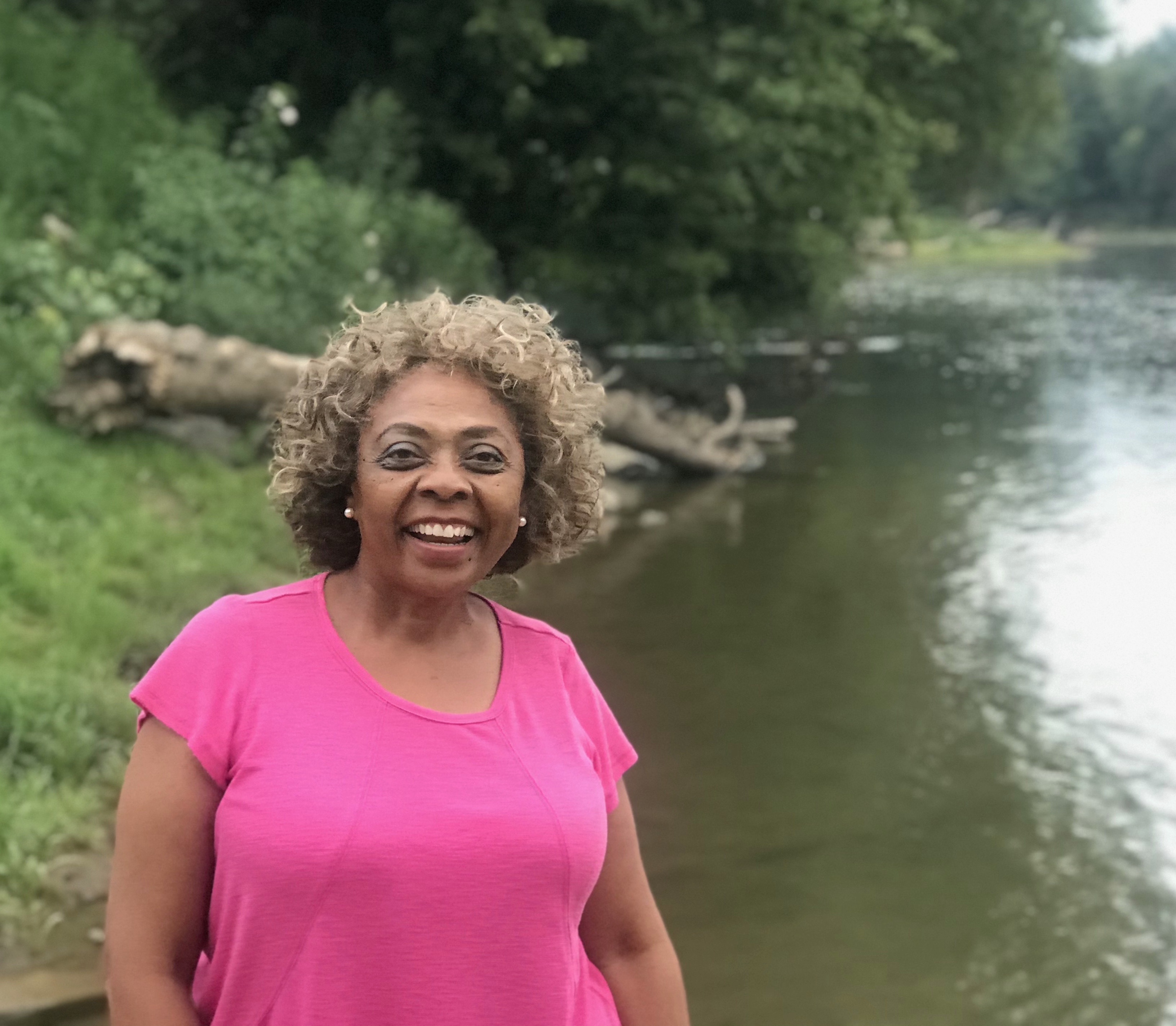 Dr. Mamie Parker laughs while standing near a lake by her home in Virginia.