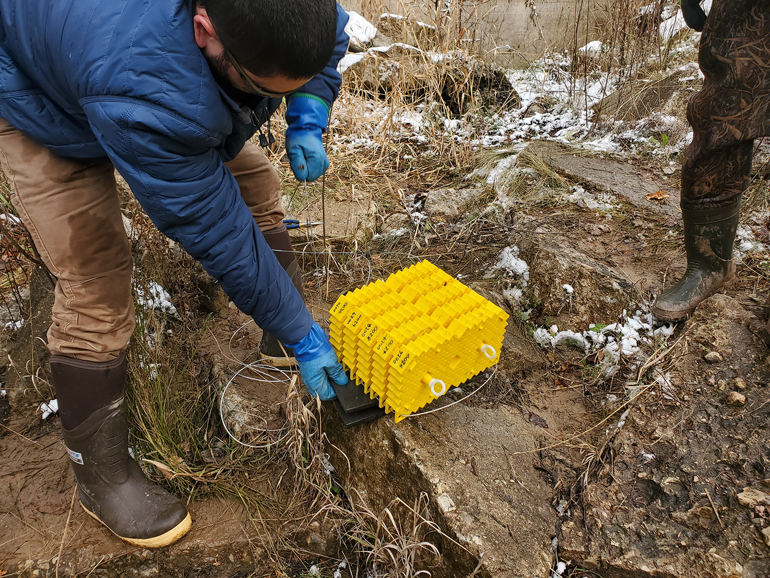 A person works with an incubator along a river in Michigan. 