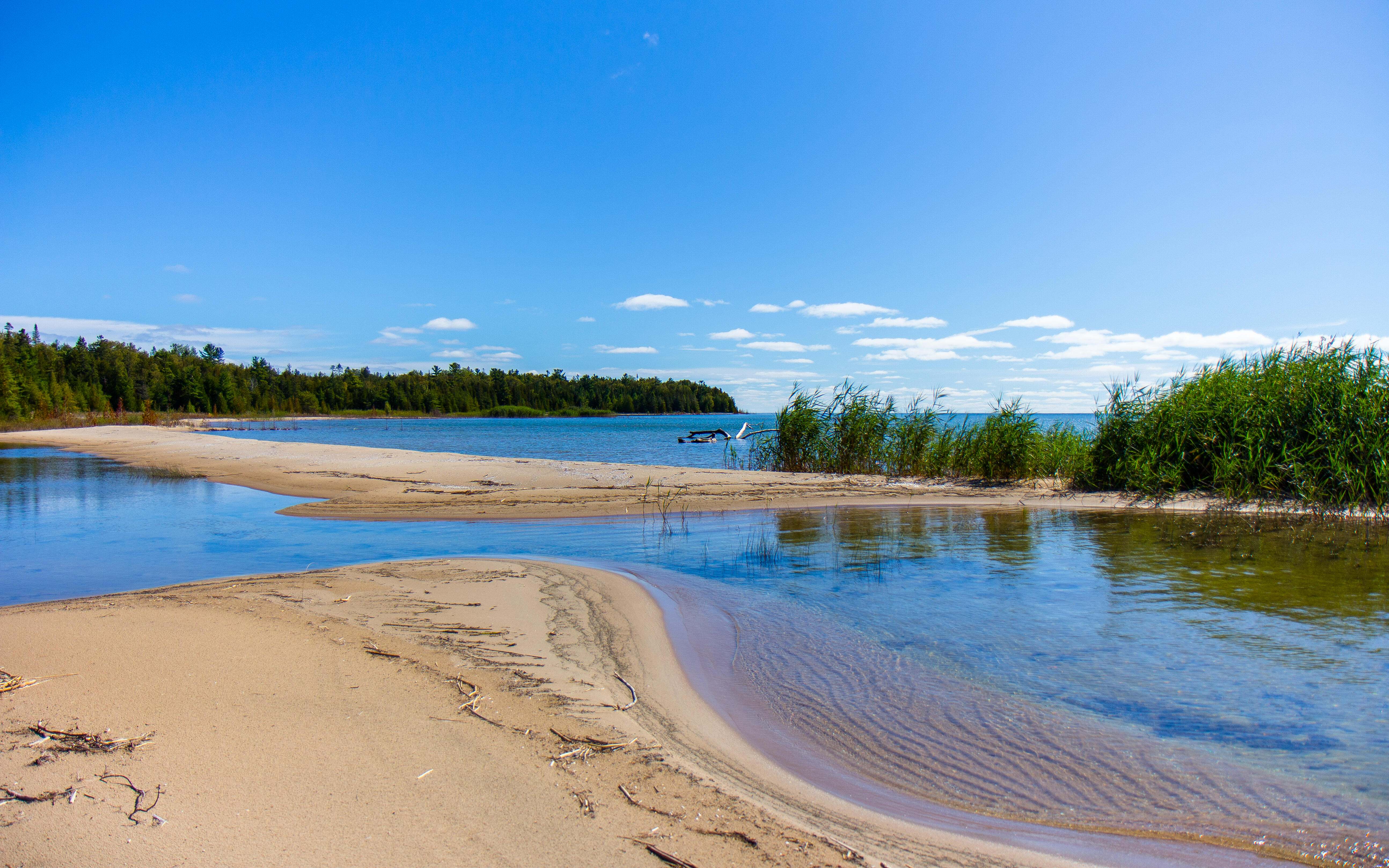 View from the shore of the North Point property. The water of Lake Huron is bright blue as is the sky.  