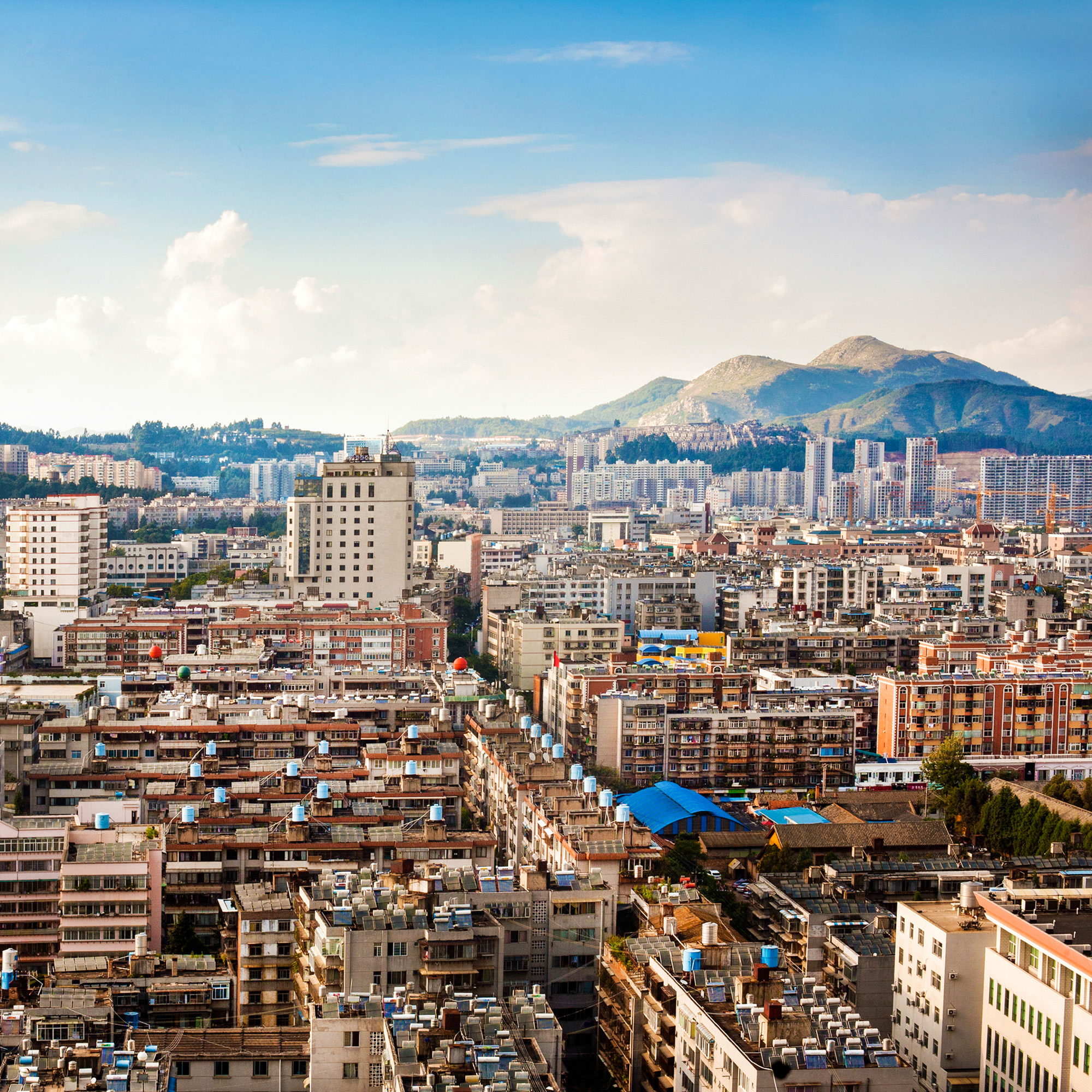 view of dense city in foreground with mountains behind