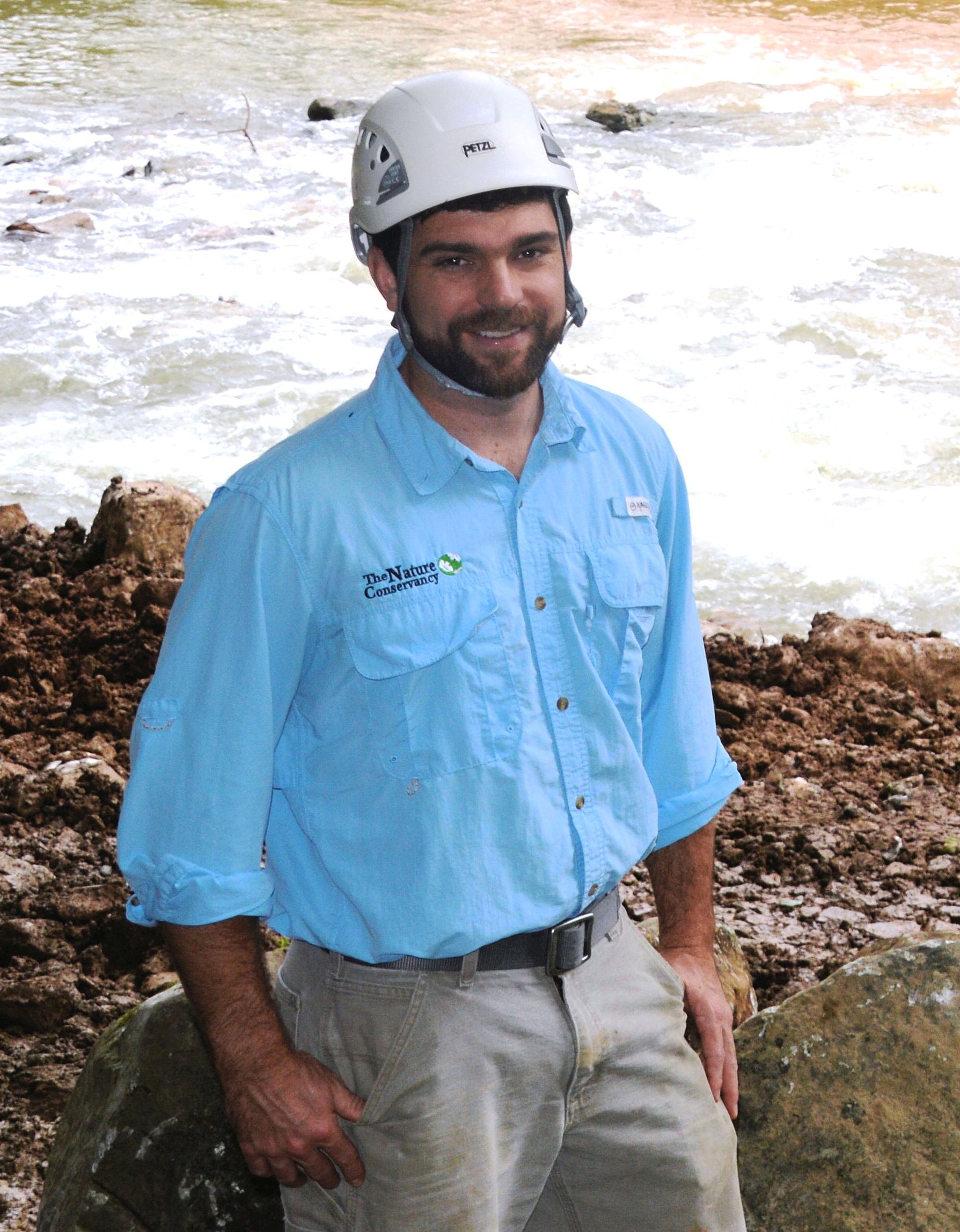 Head shot of a man with a blue Nature Conservancy shirt.