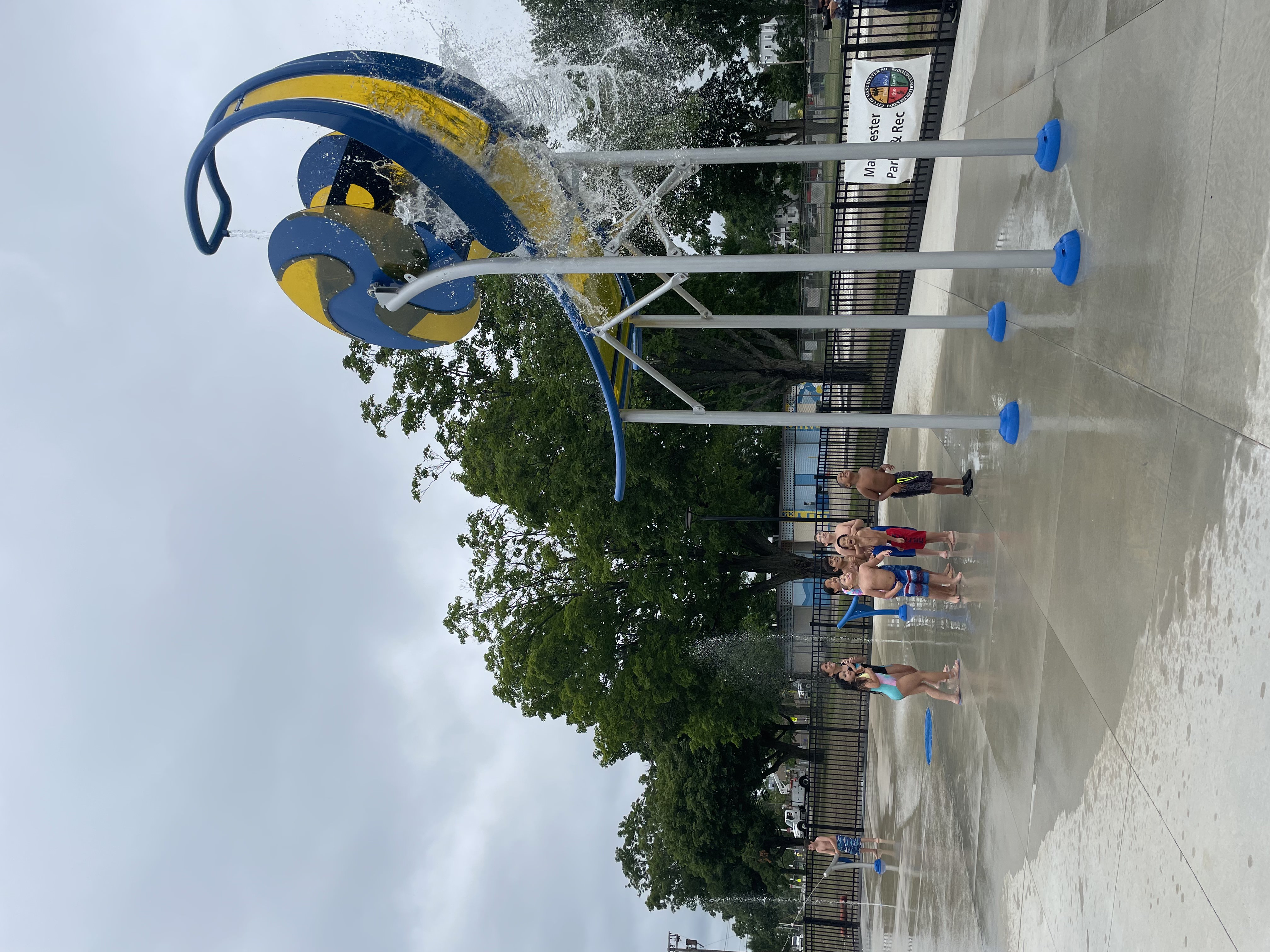 Children playing on a splash pad with water all around.