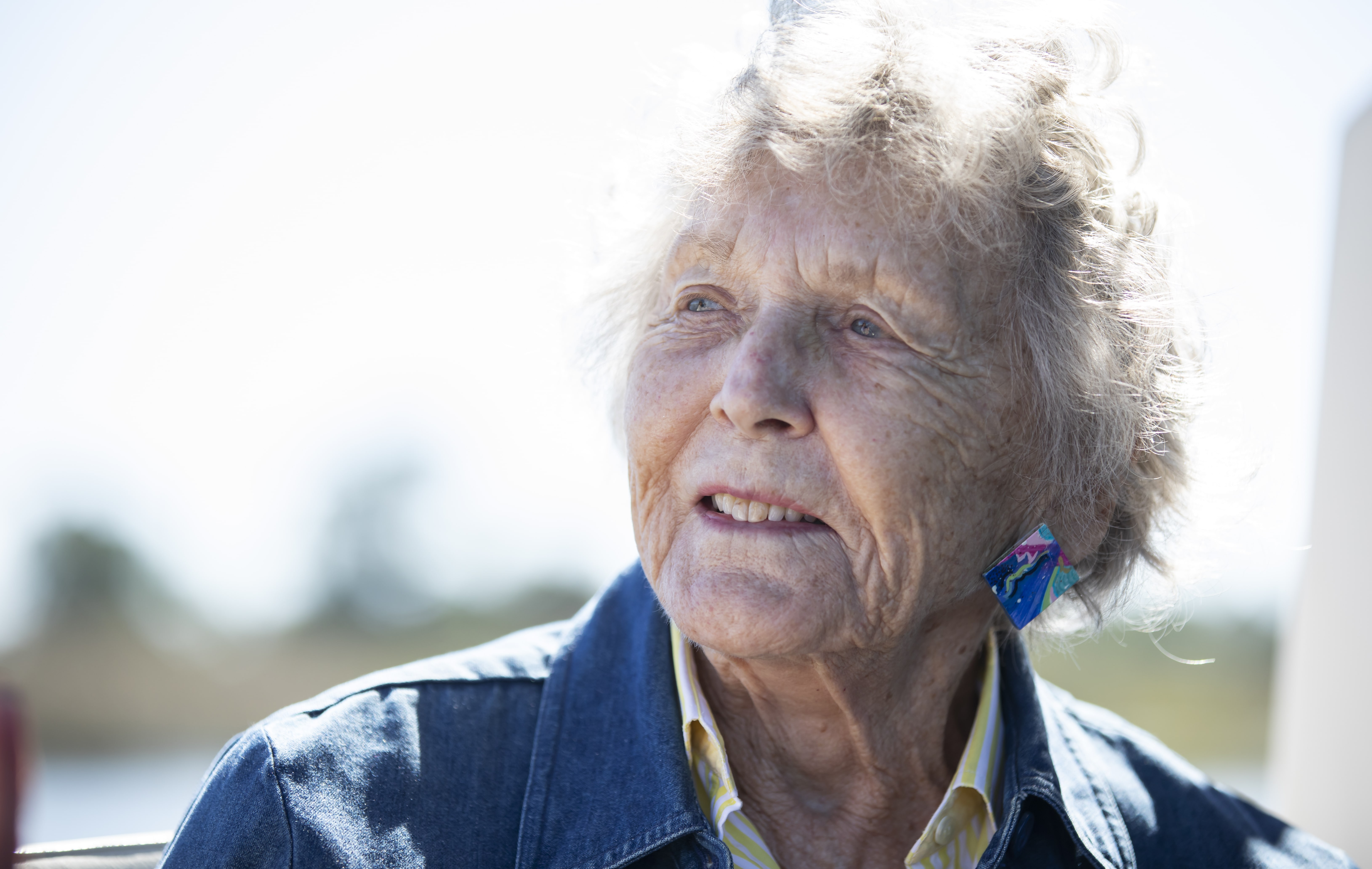 An elderly woman looks off in the distance.