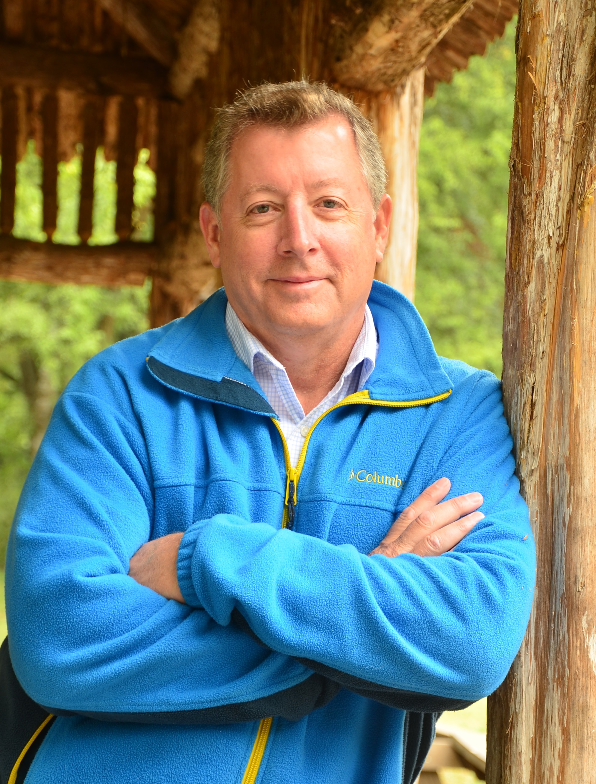 A man crosses his arms and leans against a wall.