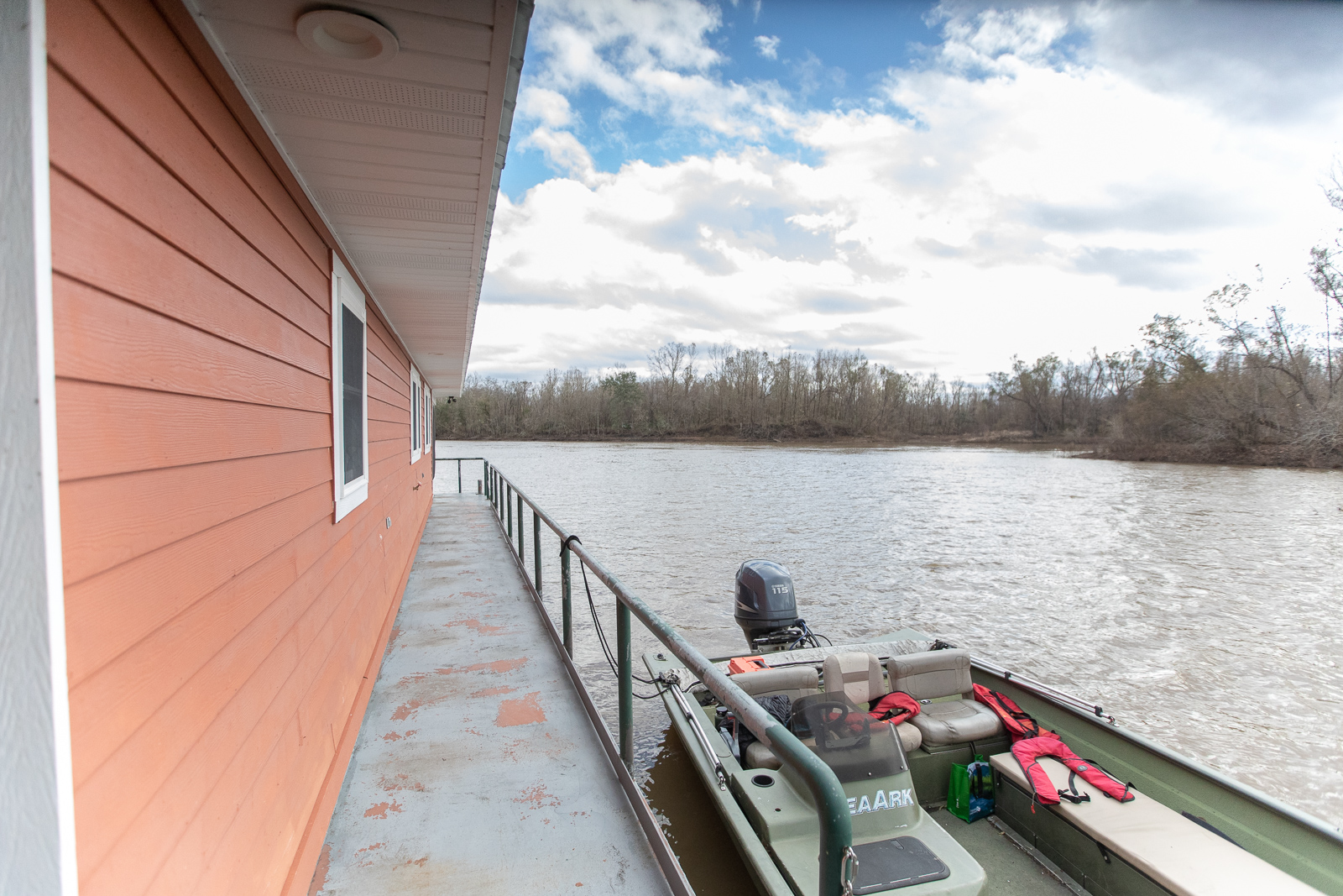 Water flows past a house boat and a smaller boat.