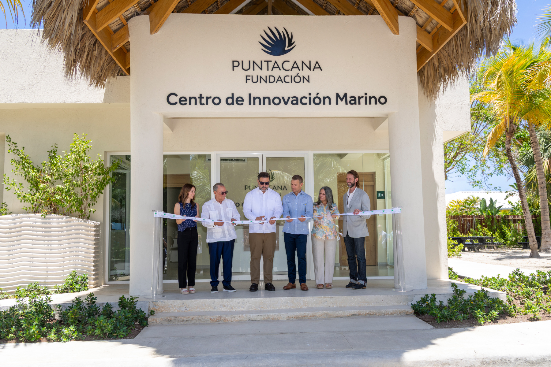 A group of people stand for a ribbon cutting ceremony at the Center for Marine Innovation in Punta Cana, Dominican Republic.