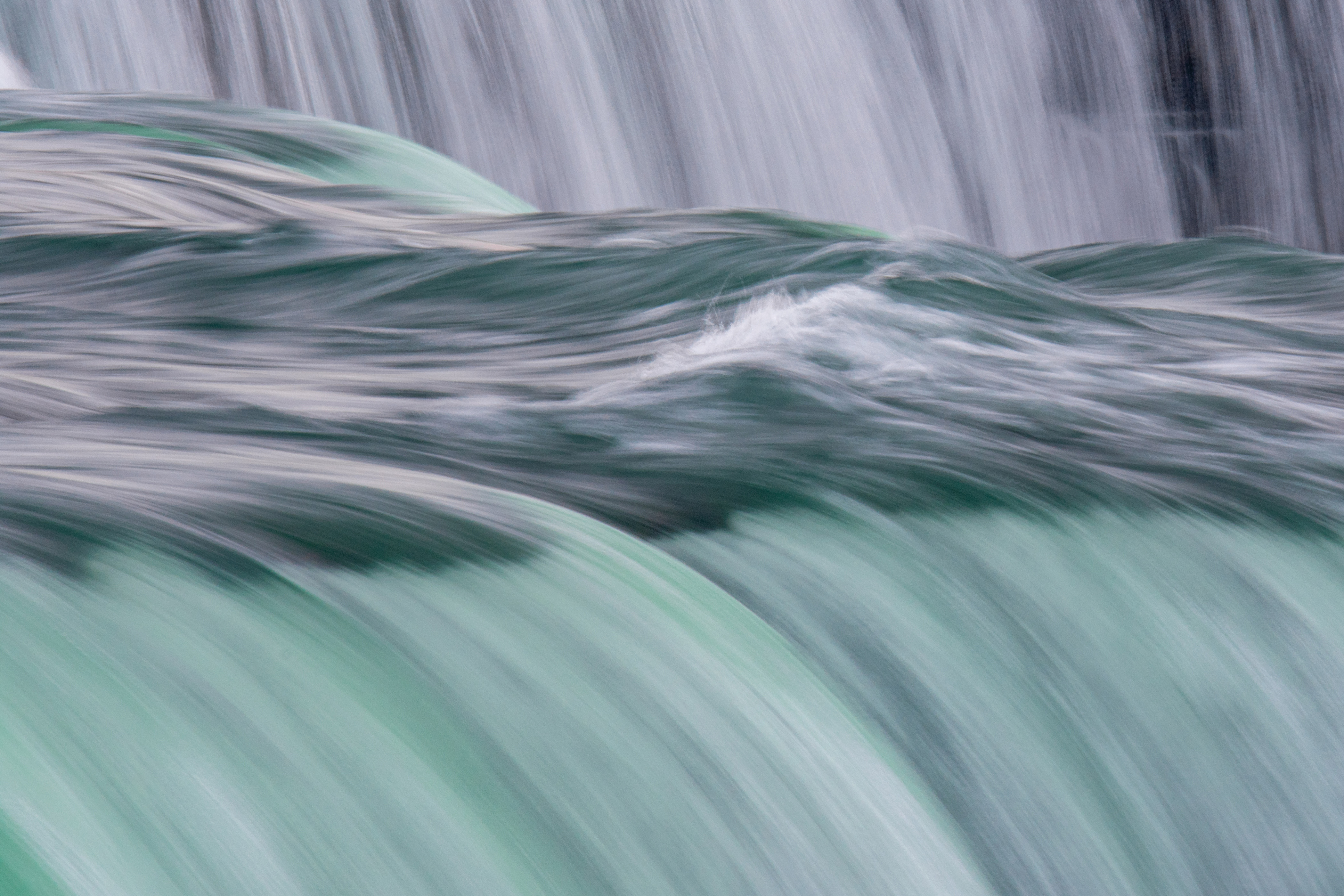 A zoomed-in photo of water rushing over Niagara Falls.