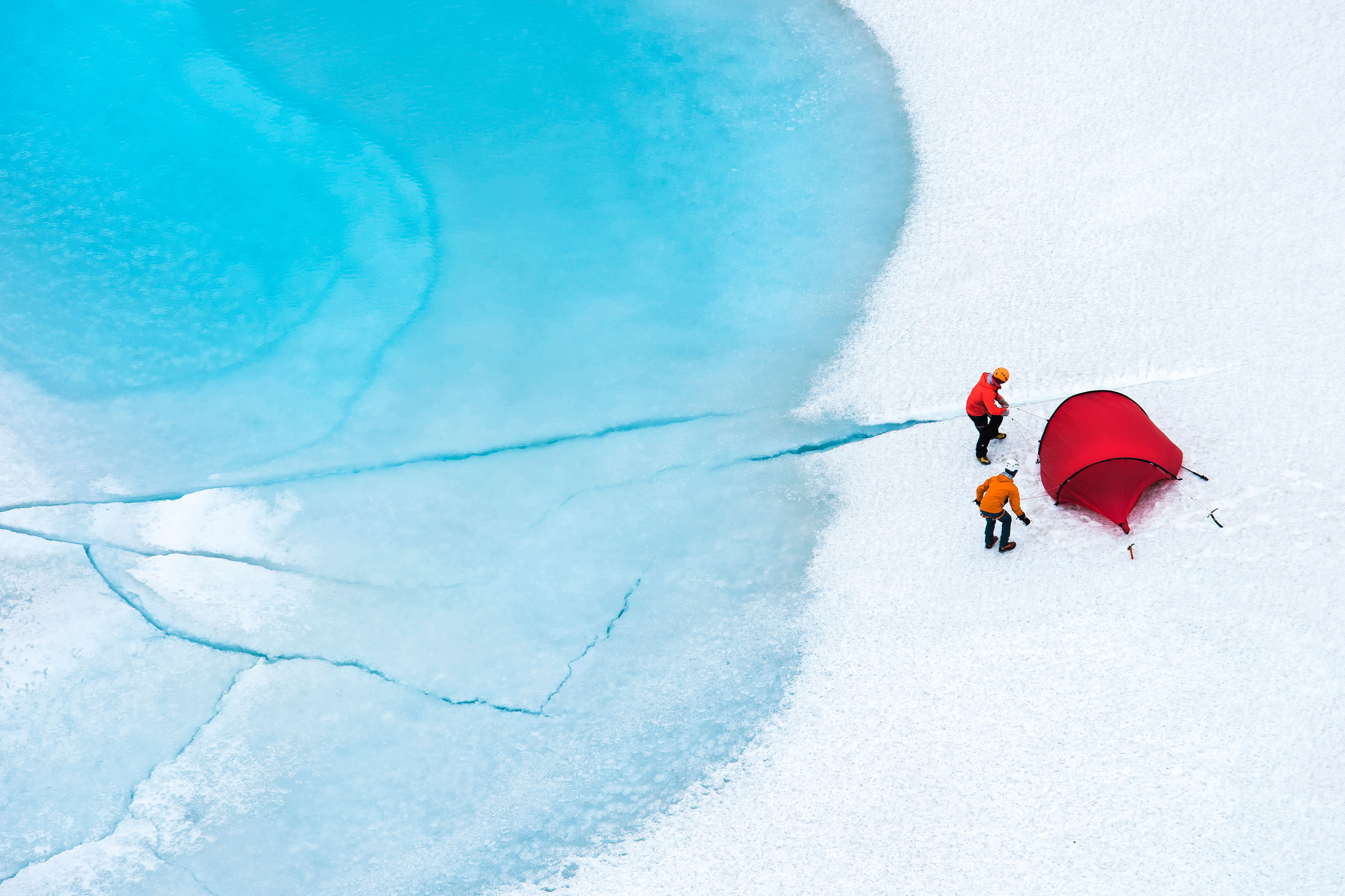 2 people and a rent tent on a snowy glacier.