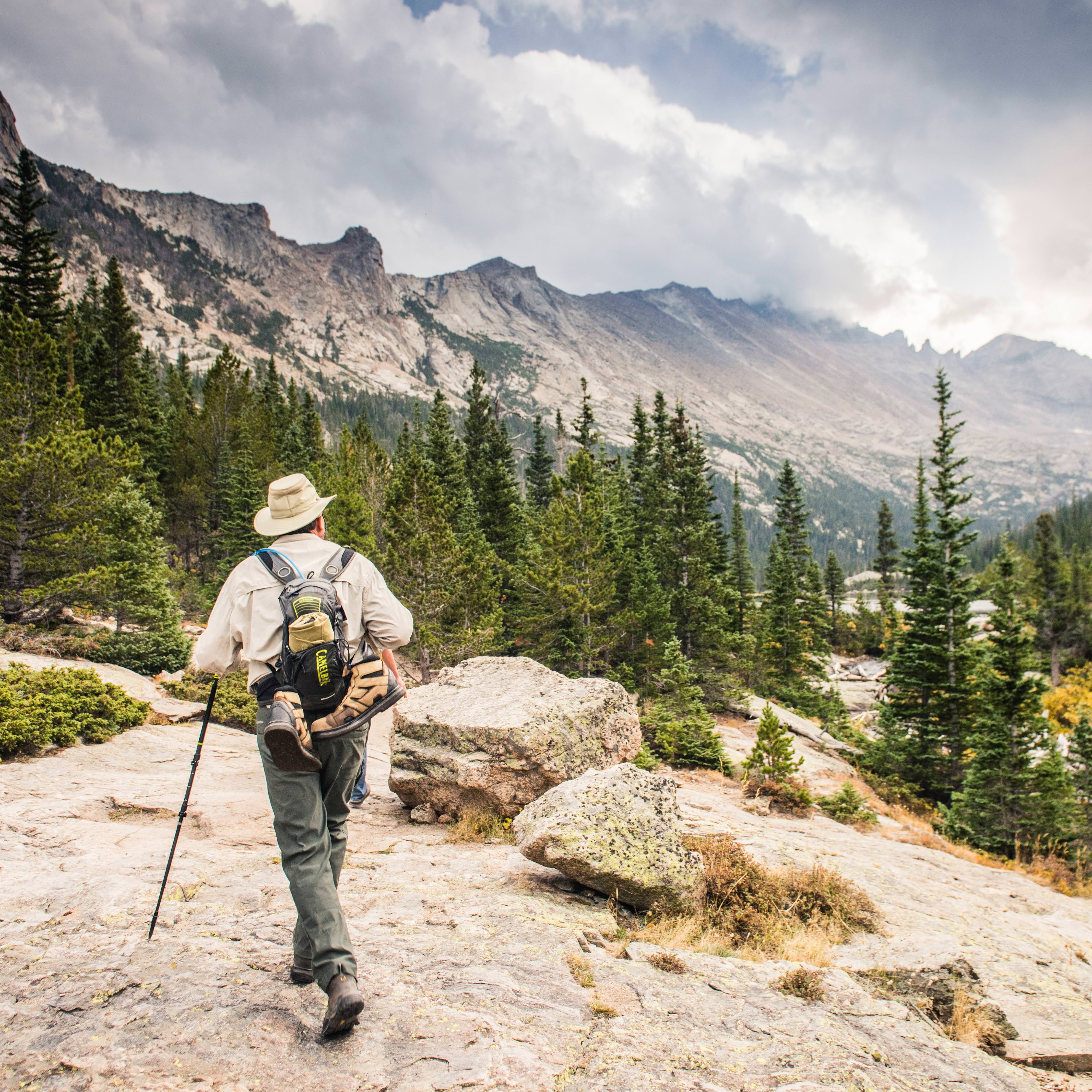 A park visitor hiking up to Mills Lake in Rocky Mountain National Park.