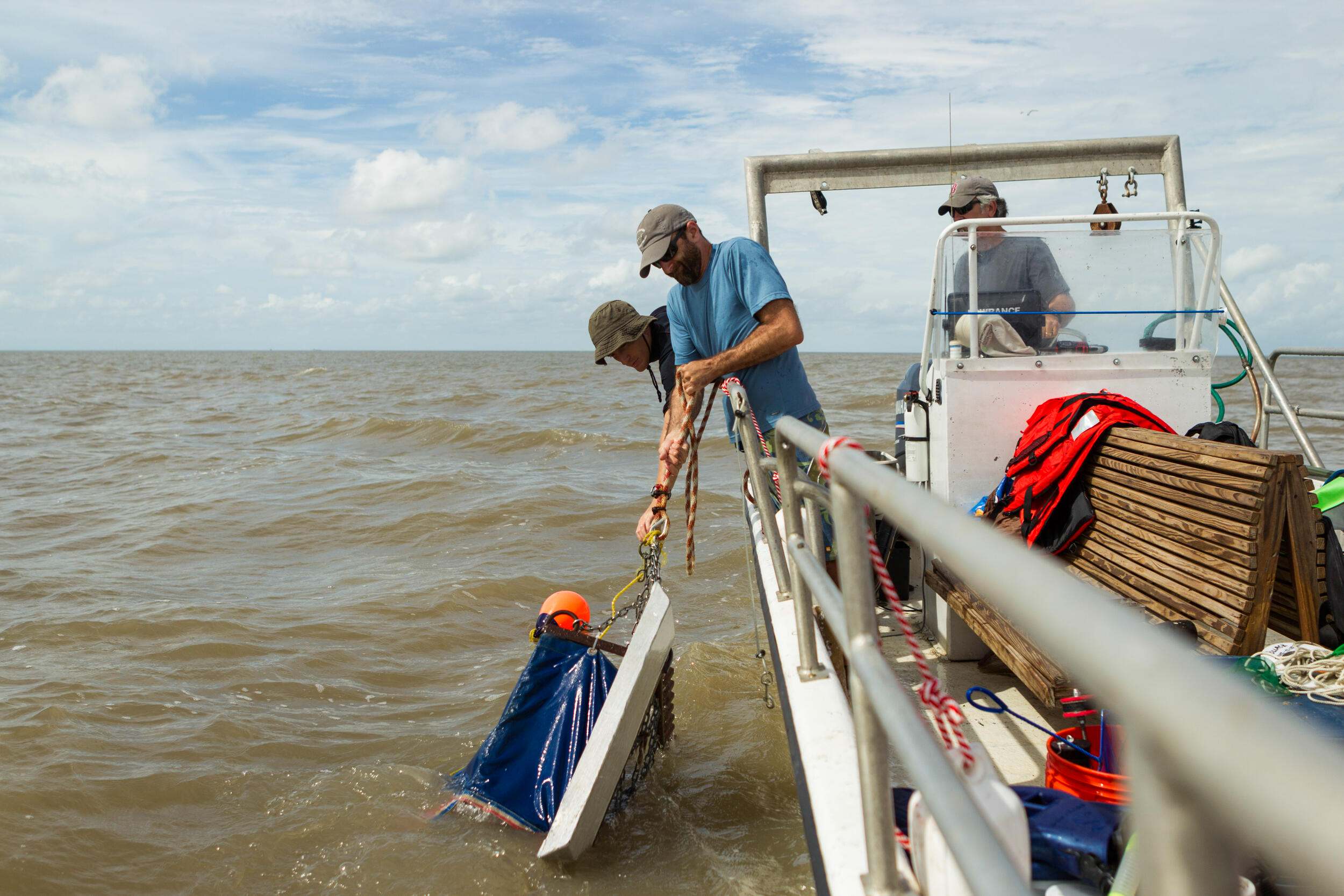 Restoration gear is lowered down the side of a boat out on the water.