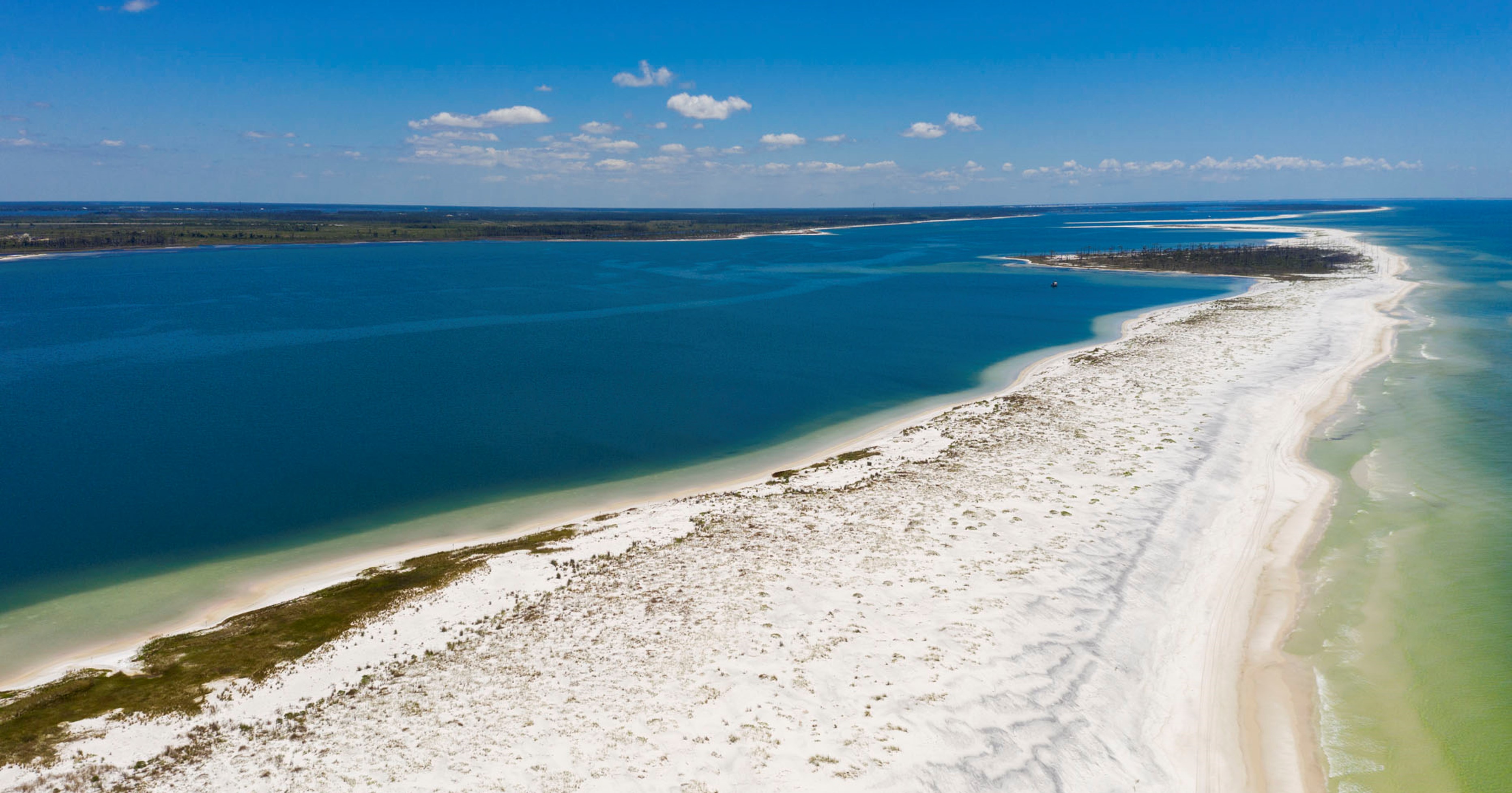 A long stretch of sandy beach and blue waters.