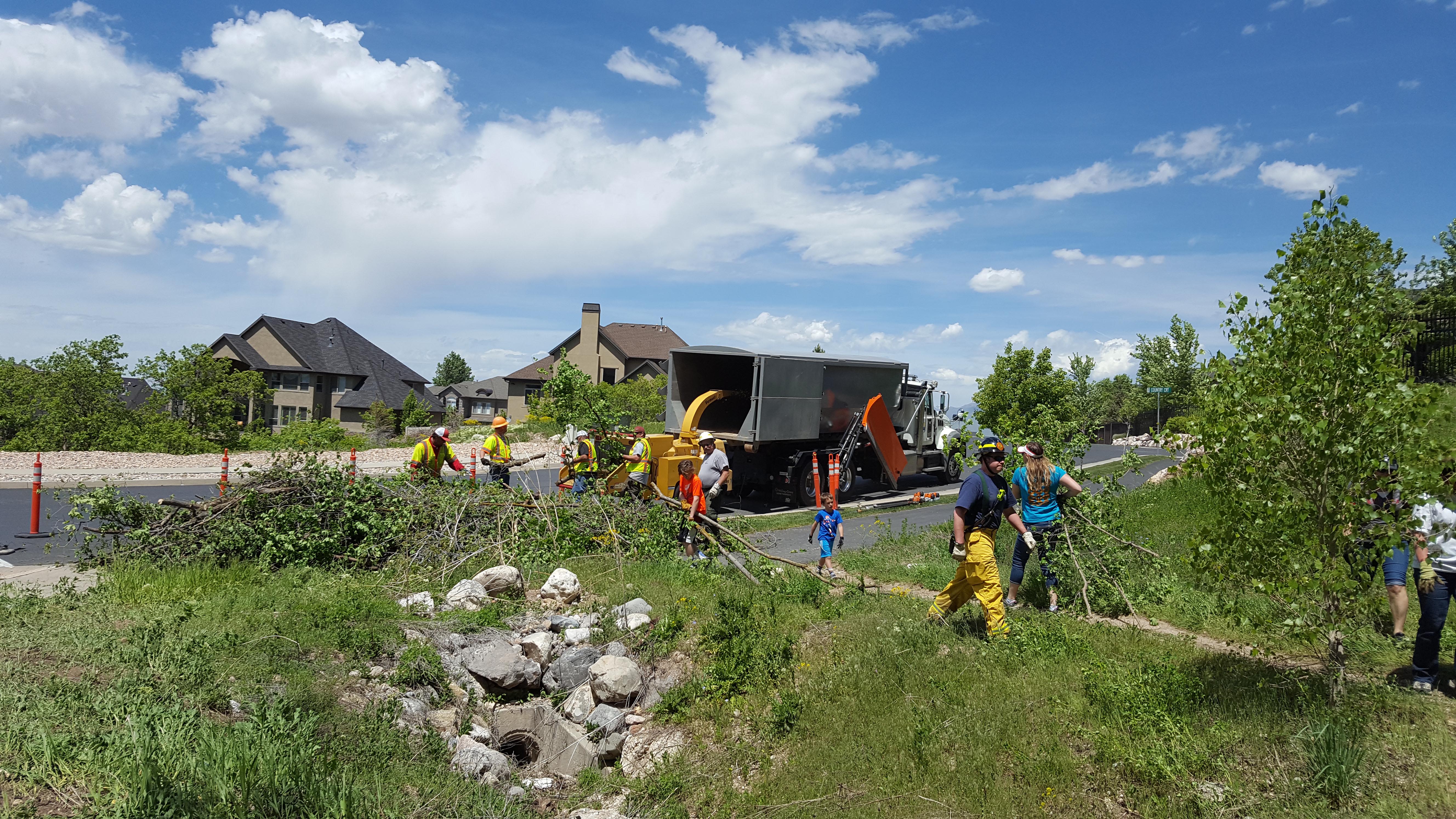 A team of 5 people pick up branches in a Utah neighborhood.