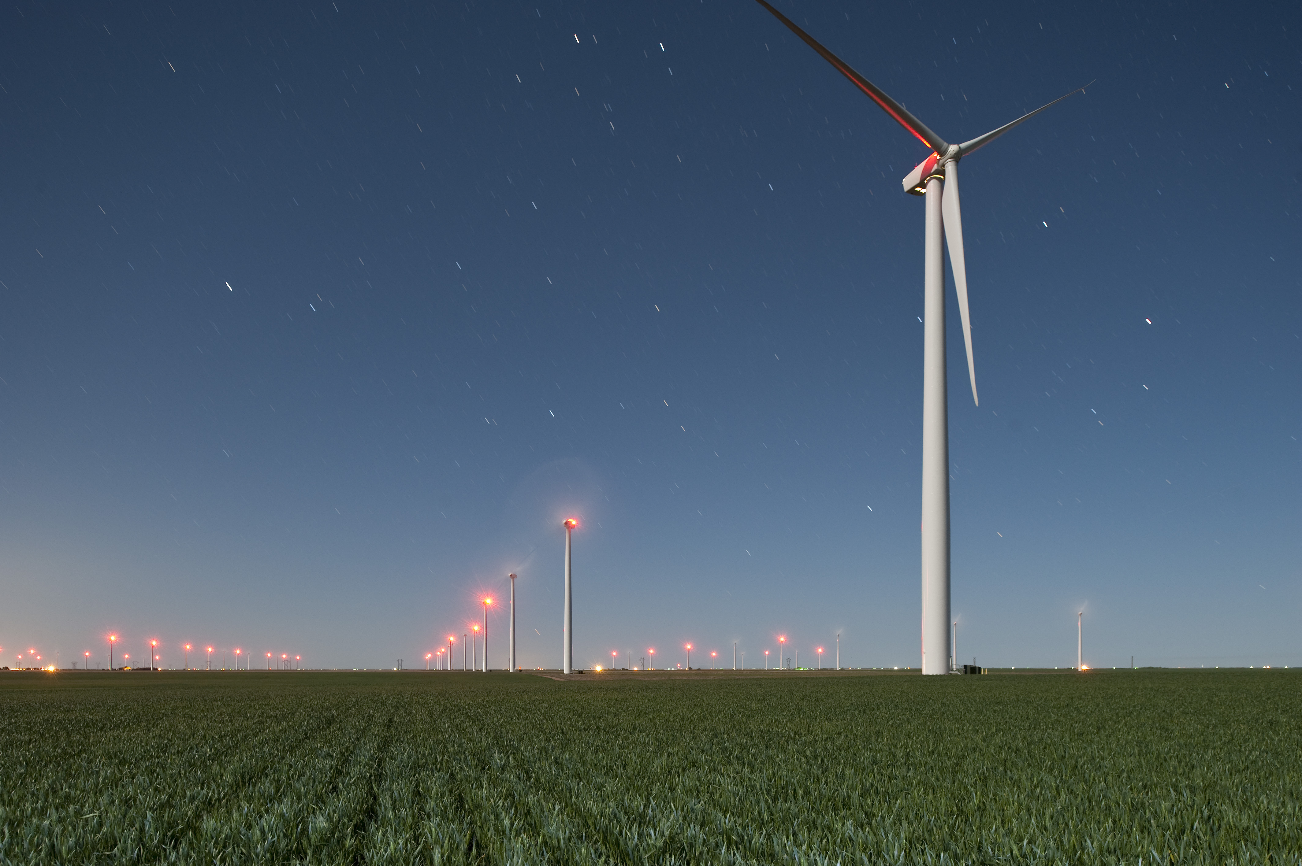 Wind turbines towering over agricultural field