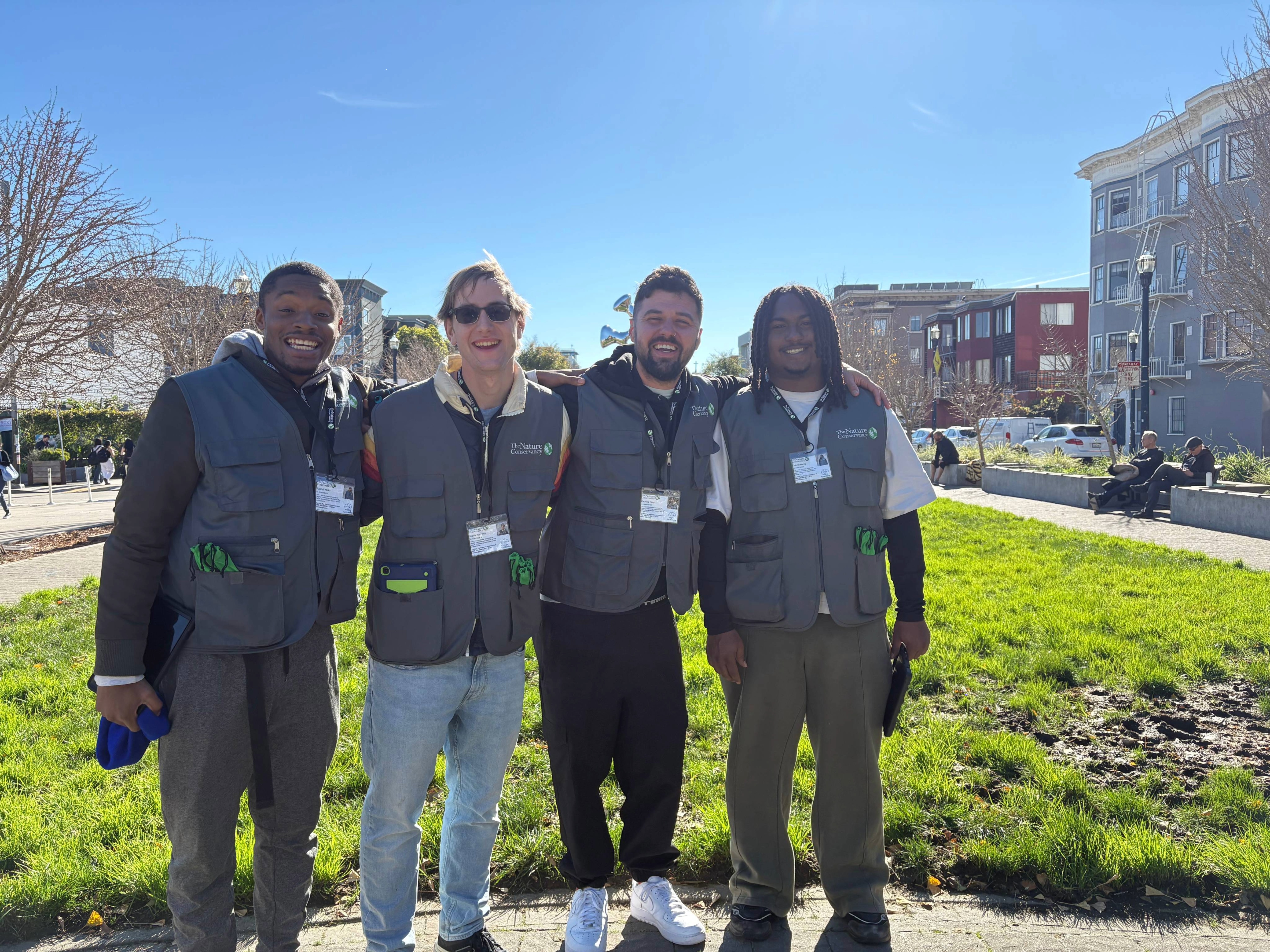Four F2F canvassers pose while smiling on a sunny day. 